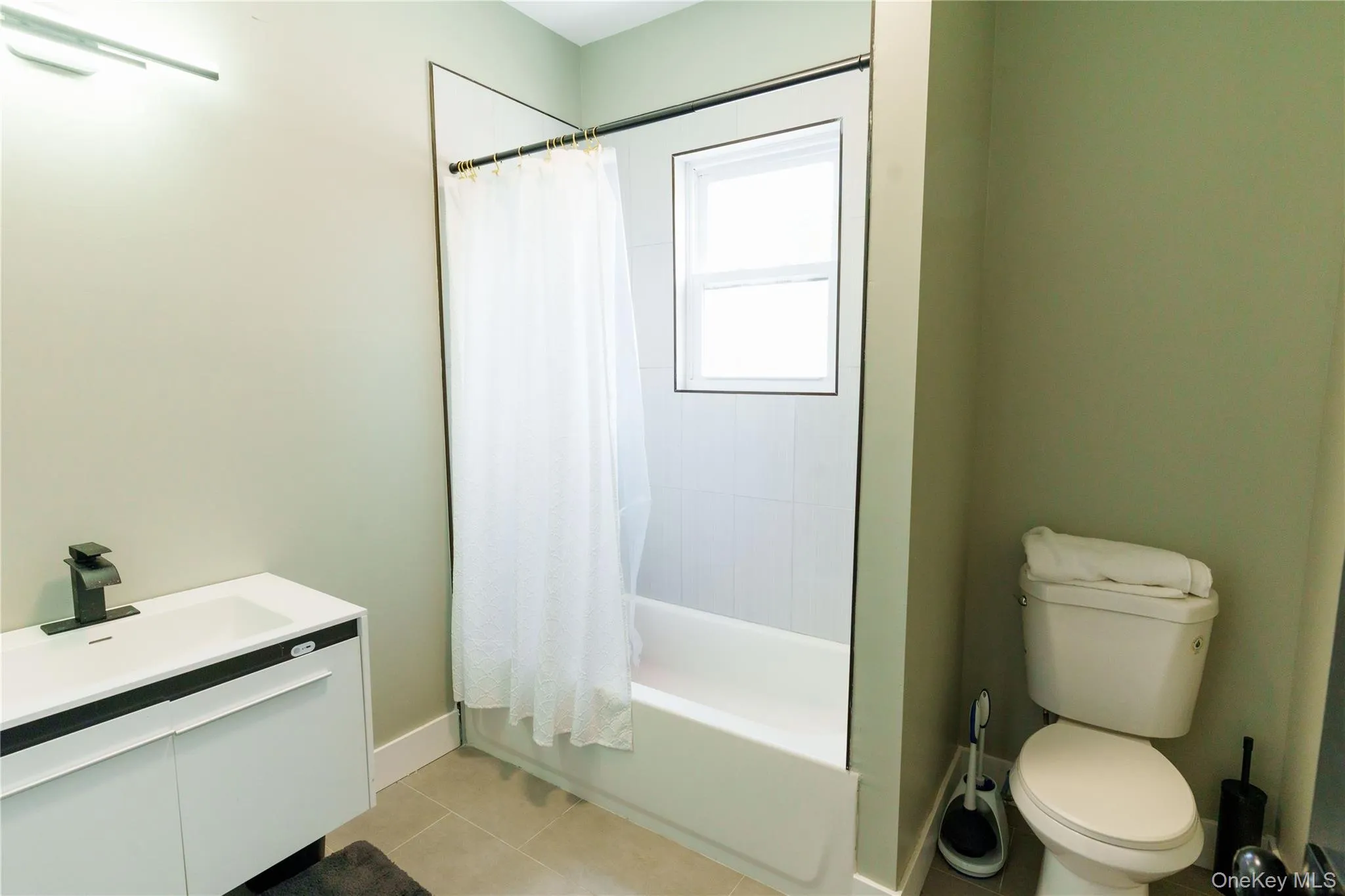 Bathroom with shower / tub combo with curtain, vanity, and tile patterned floors Bathroom with shower / tub combo with curtain, vanity, and tile patterned floors