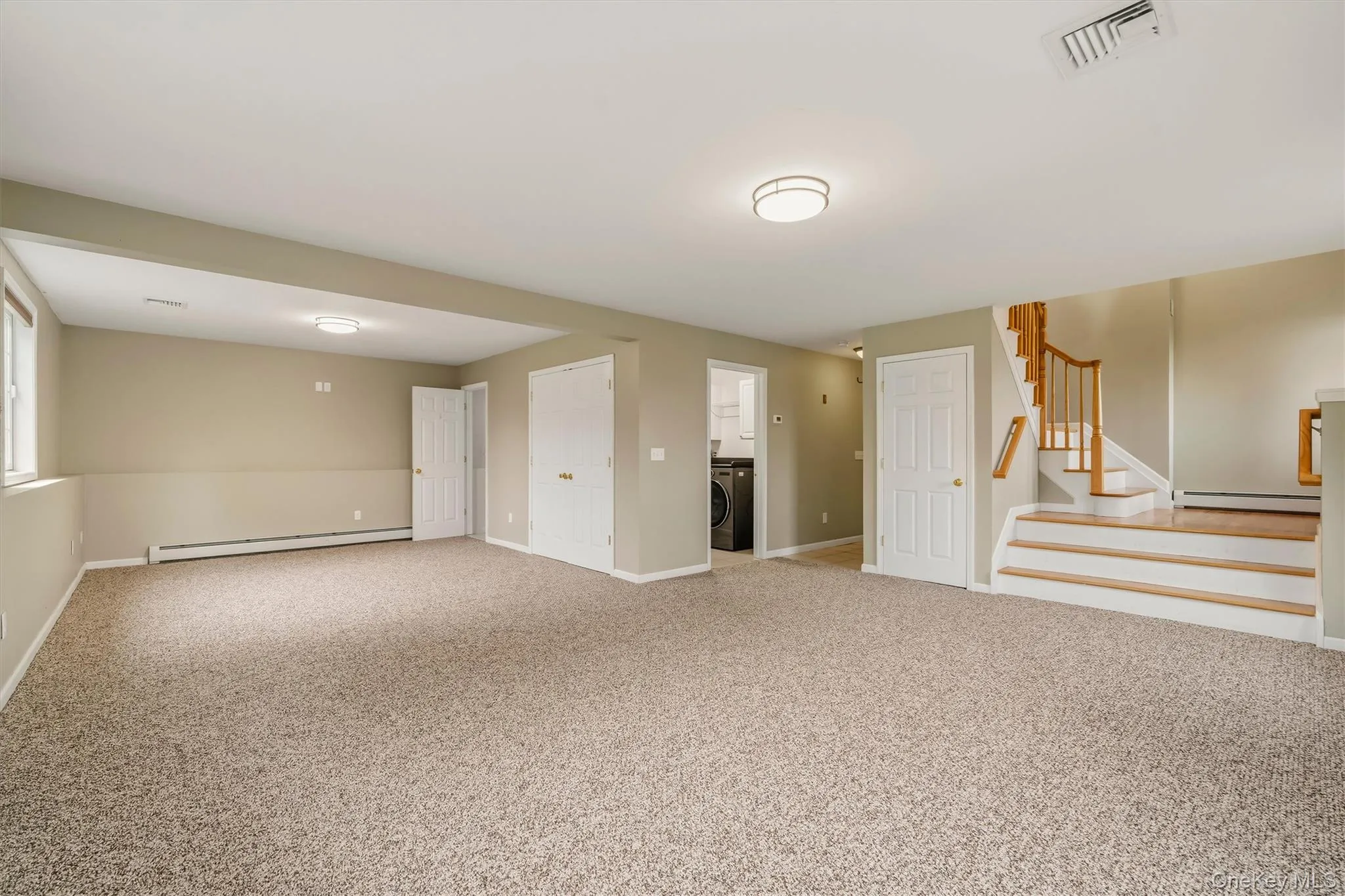 Expansive carpeted area with neutral walls, recessed lighting, and a window providing natural light Expansive carpeted area with neutral walls, recessed lighting, and a window providing natural light