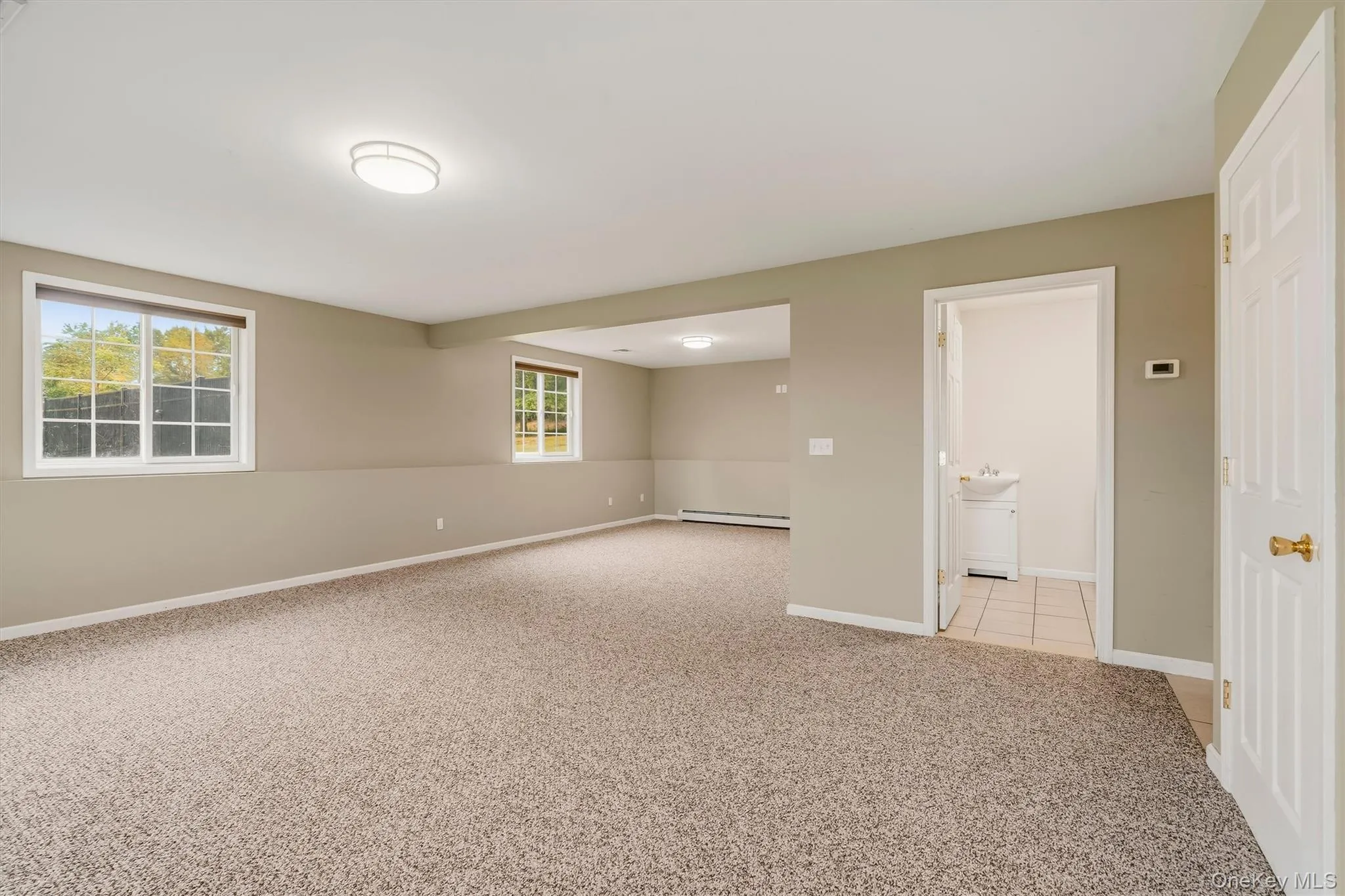 Spacious room featuring carpeting, multiple windows, and recessed lighting Spacious room featuring carpeting, multiple windows, and recessed lighting
