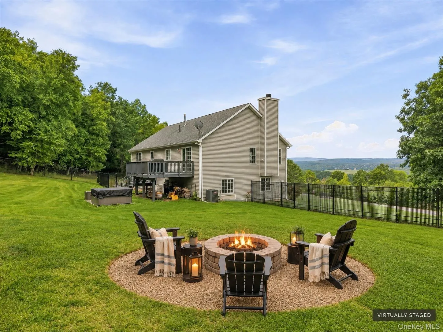 Expansive green lawn with a built-in fire pit, a multi-level deck, and a hot tub Expansive green lawn with a built-in fire pit, a multi-level deck, and a hot tub