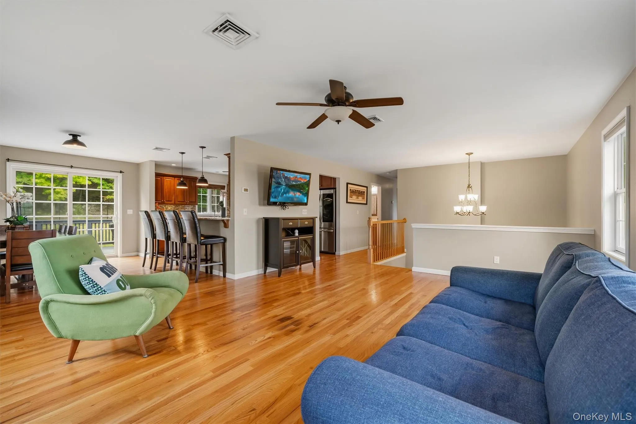 Open-concept living area featuring wood-finish flooring and a ceiling fan Open-concept living area featuring wood-finish flooring and a ceiling fan