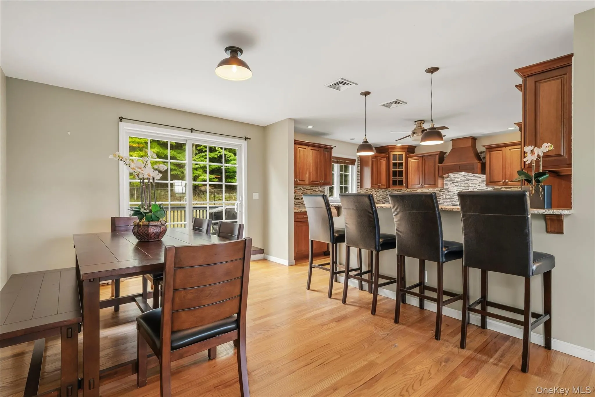Hardwood flooring throughout, kitchen with wood cabinetry, stone backsplash, and recessed lighting Hardwood flooring throughout, kitchen with wood cabinetry, stone backsplash, and recessed lighting