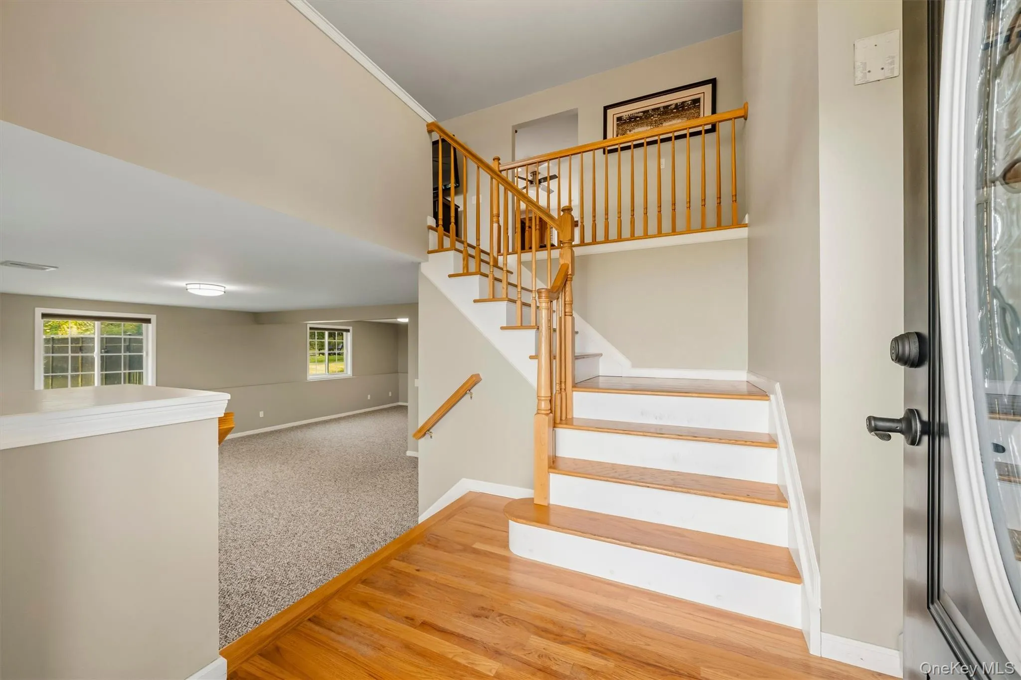 Hardwood flooring entry with wood and white staircase Hardwood flooring entry with wood and white staircase