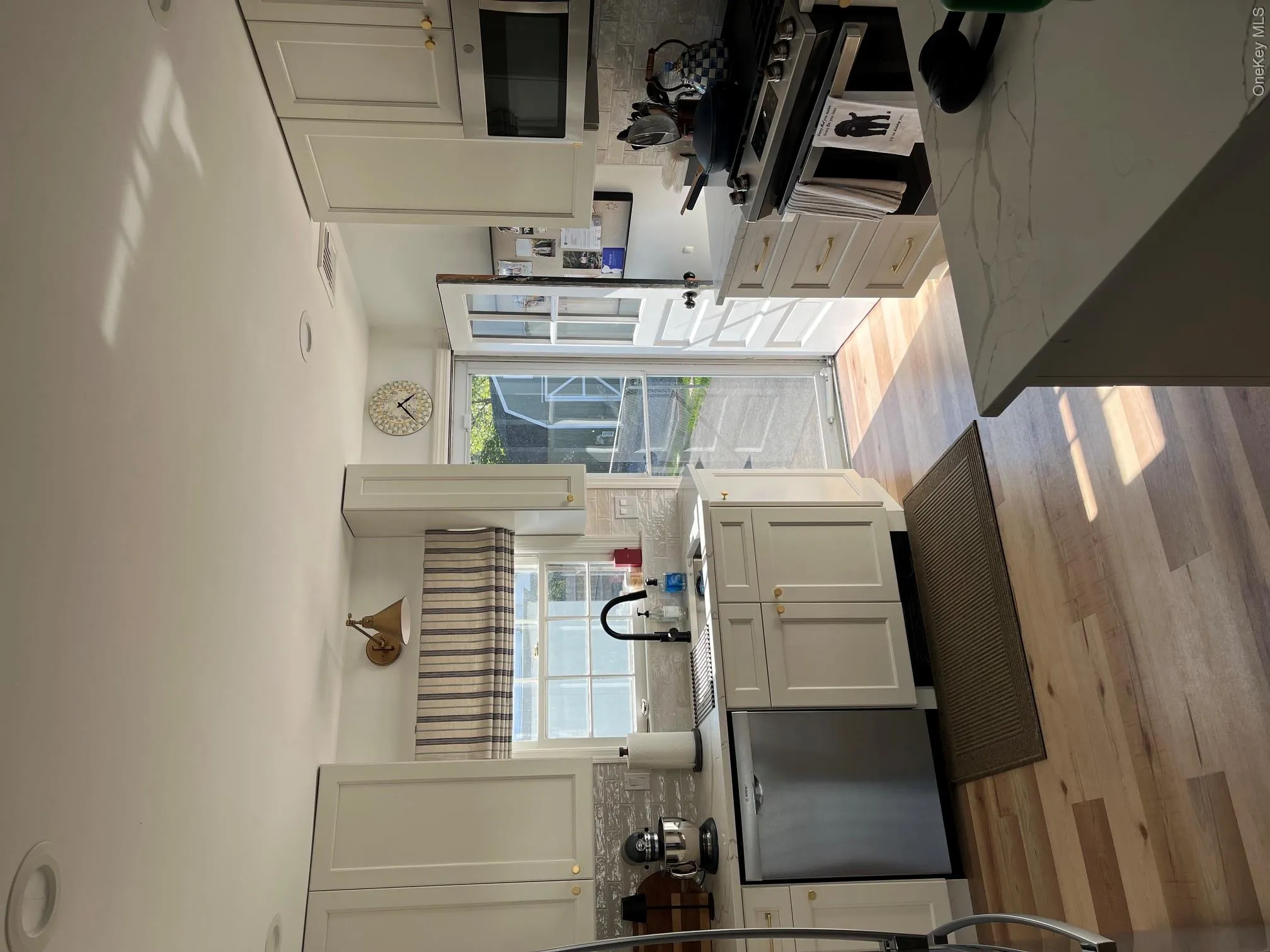White shaker-style cabinetry, stainless steel appliances, Luxury Vinyl flooring, light-toned countertop, and tile backsplash White shaker-style cabinetry, stainless steel appliances, Luxury Vinyl flooring, light-toned countertop, and tile backsplash