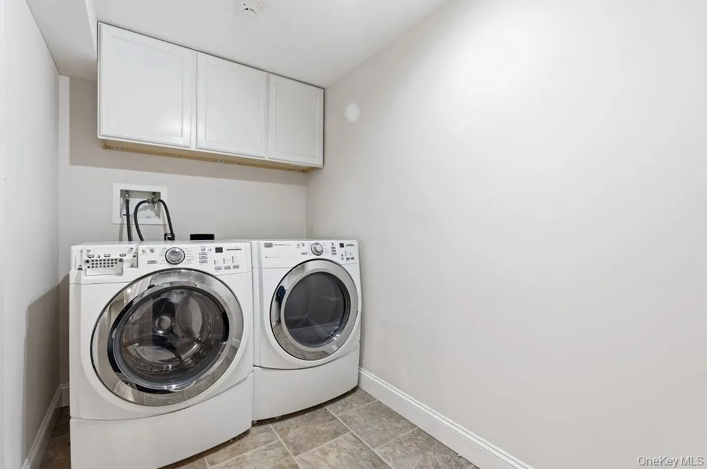 Built-in overhead white cabinetry, light-toned wall paint, and tiled flooring Built-in overhead white cabinetry, light-toned wall paint, and tiled flooring