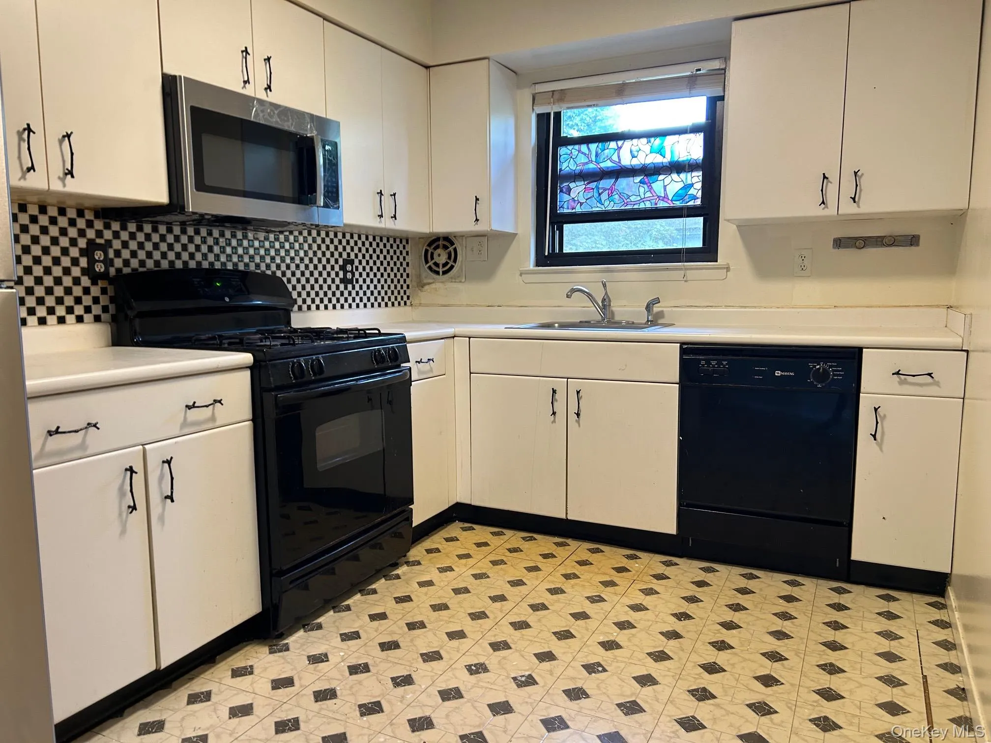 Kitchen with black appliances, light countertops, and light floors Kitchen with black appliances, light countertops, and light floors