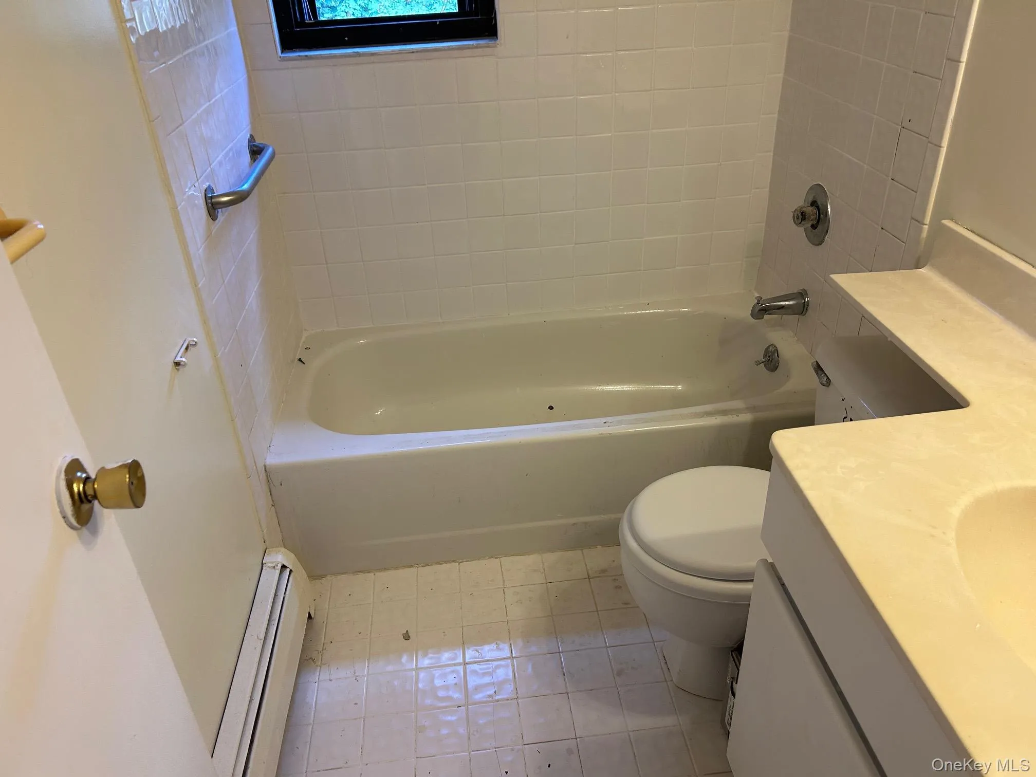 Bathroom with vanity, a baseboard radiator, shower / bath combination, and light tile patterned floors Bathroom with vanity, a baseboard radiator, shower / bath combination, and light tile patterned floors