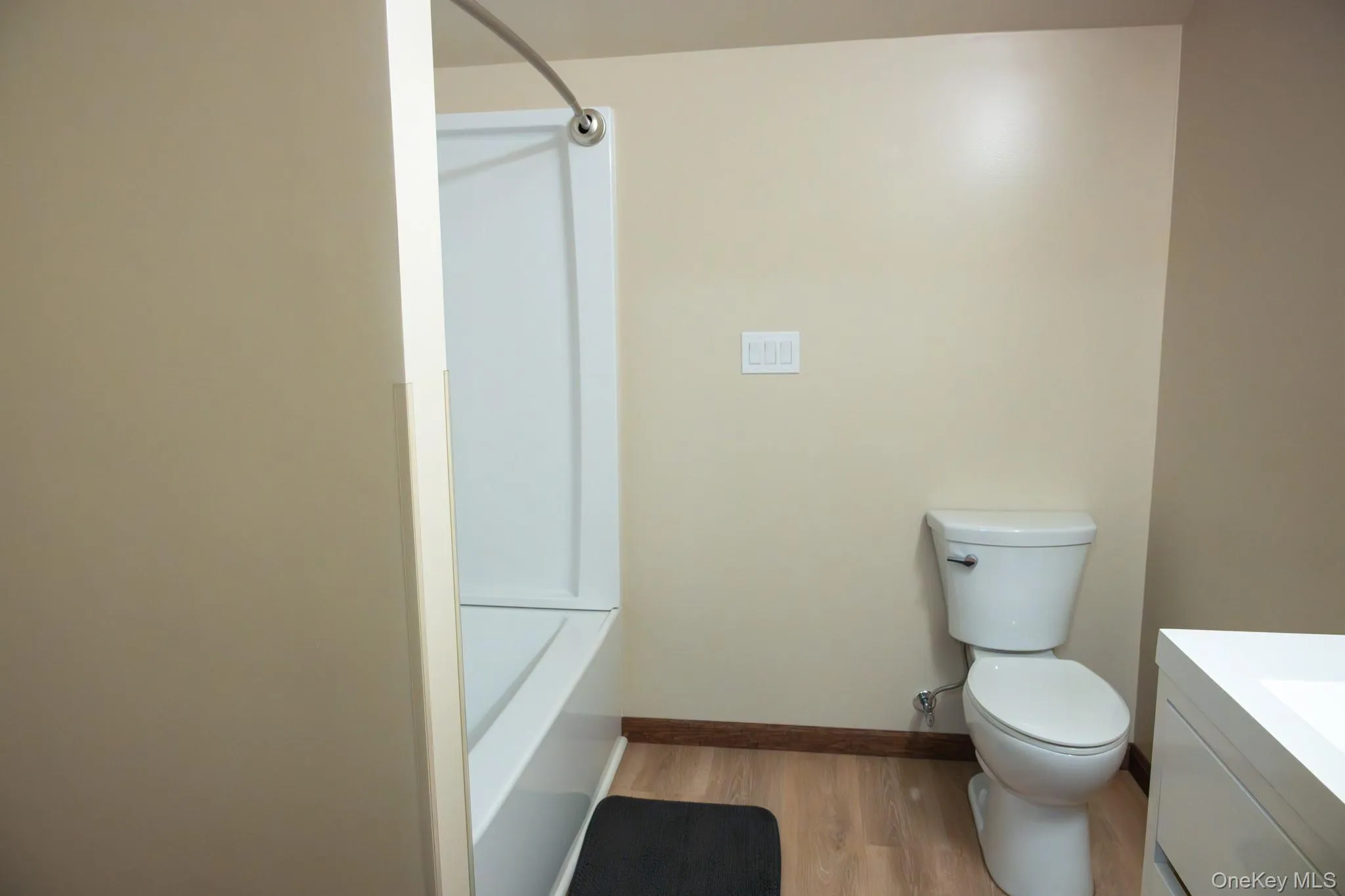 White toilet and bathtub with a curved shower rod White toilet and bathtub with a curved shower rod