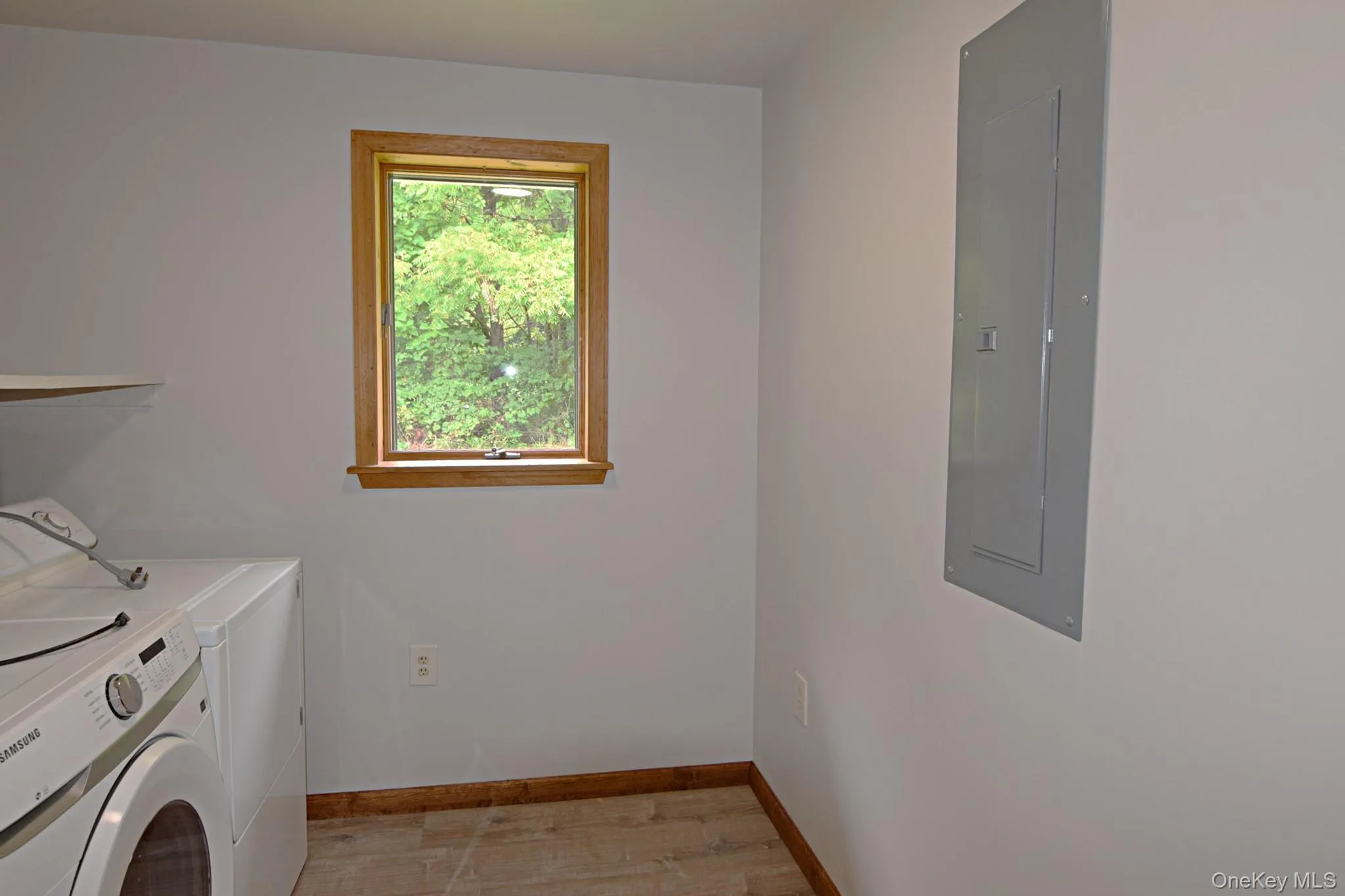 Recessed window with wood trim, built-in shelving, and wood-finish flooring.Washer and Dryer.Location of the electrical box Recessed window with wood trim, built-in shelving, and wood-finish flooring.Washer and Dryer.Location of the electrical box