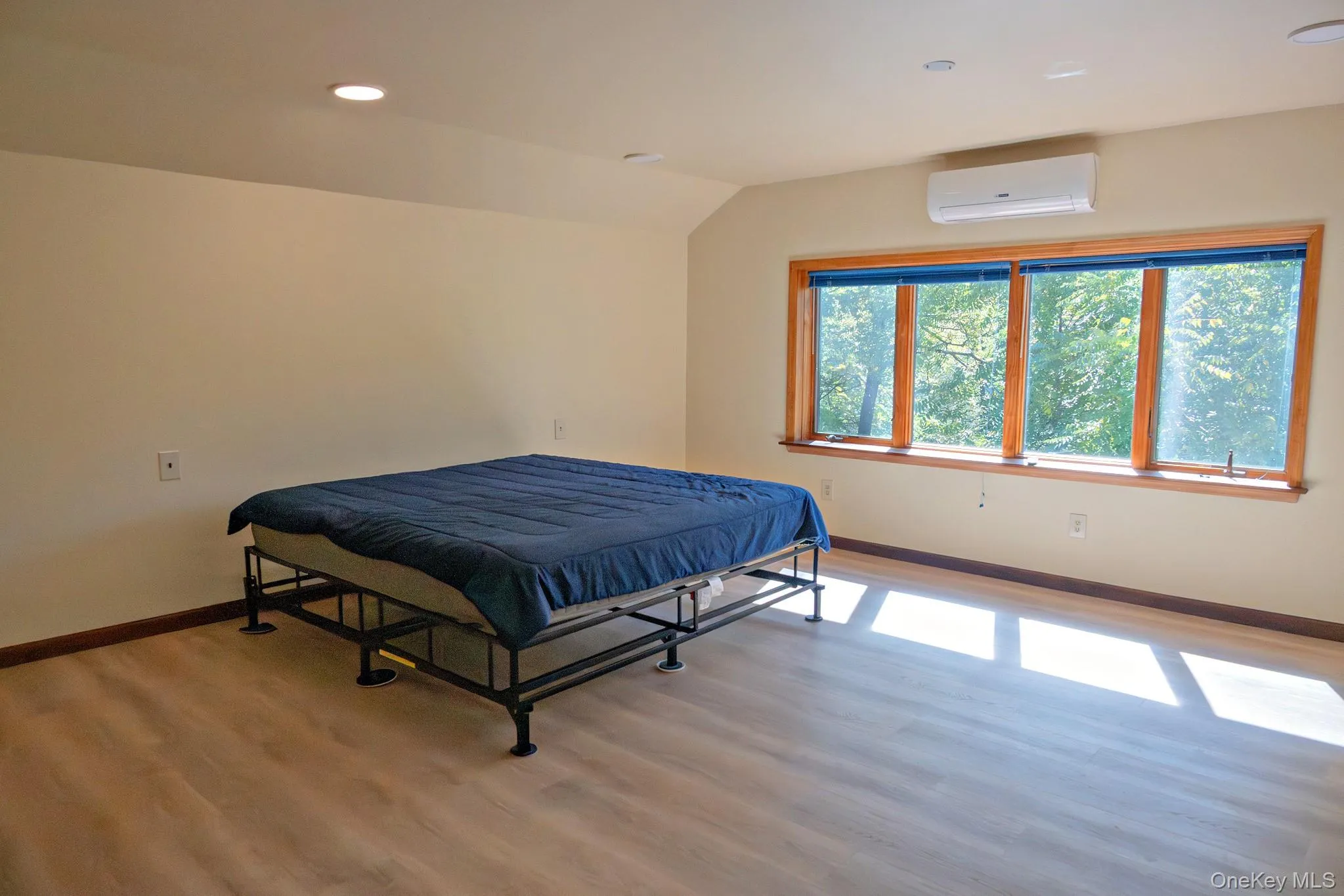 Recessed lighting illuminates the spacious room with wood-finish flooring Recessed lighting illuminates the spacious room with wood-finish flooring