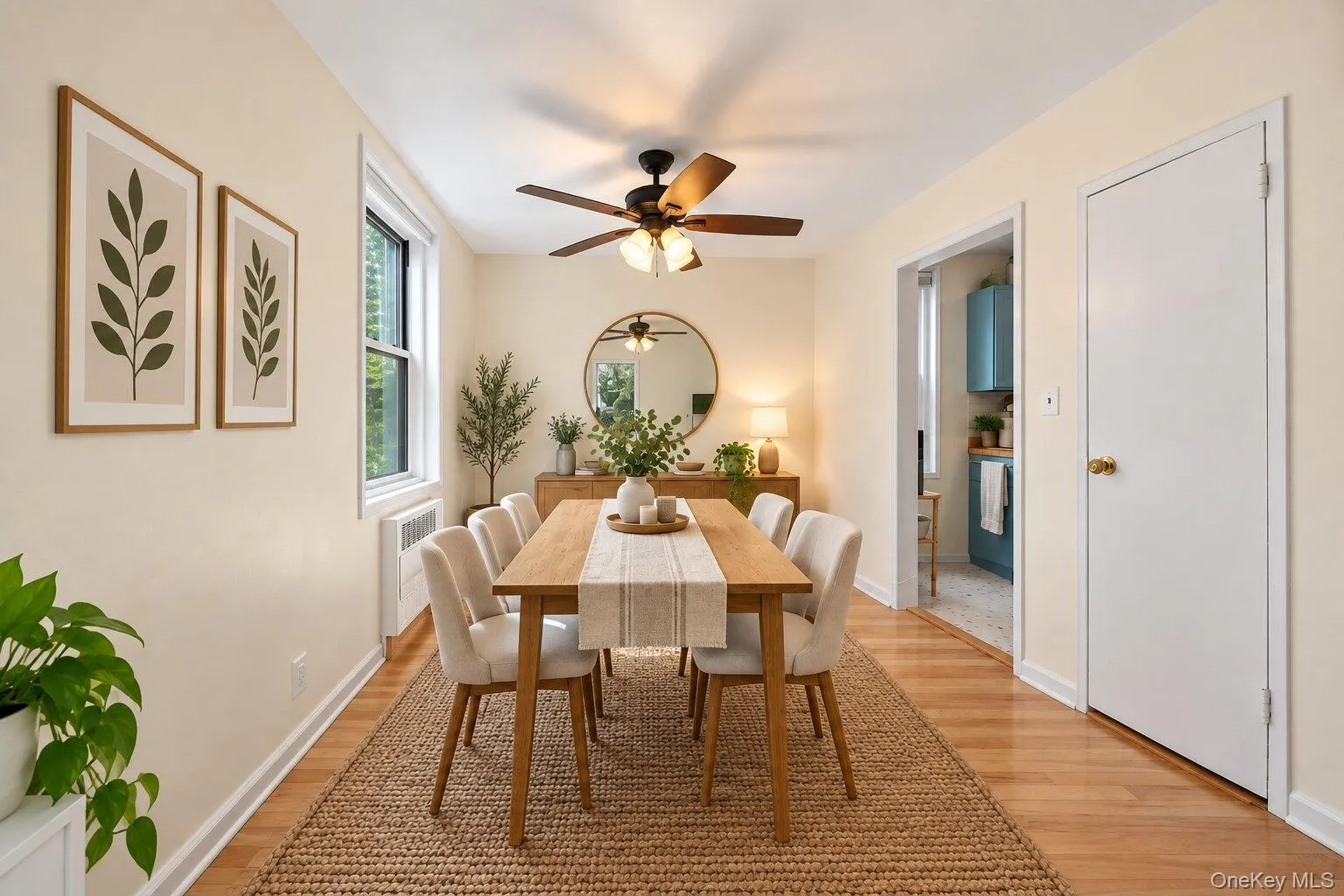 Elegant dining room featuring hardwood flooring, a wood-finish dining table with seating for six, and a natural fiber area rug Elegant dining room featuring hardwood flooring, a wood-finish dining table with seating for six, and a natural fiber area rug