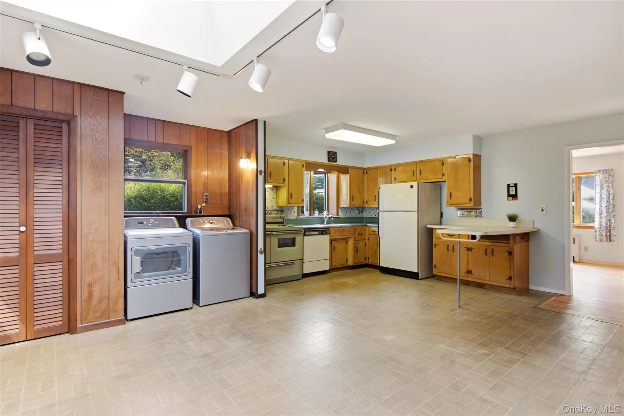 Kitchen with pantry closet, laundry, wood cabinets and breakfast bar. (Dishwasher AS-IS) Kitchen with pantry closet, laundry, wood cabinets and breakfast bar. (Dishwasher AS-IS)