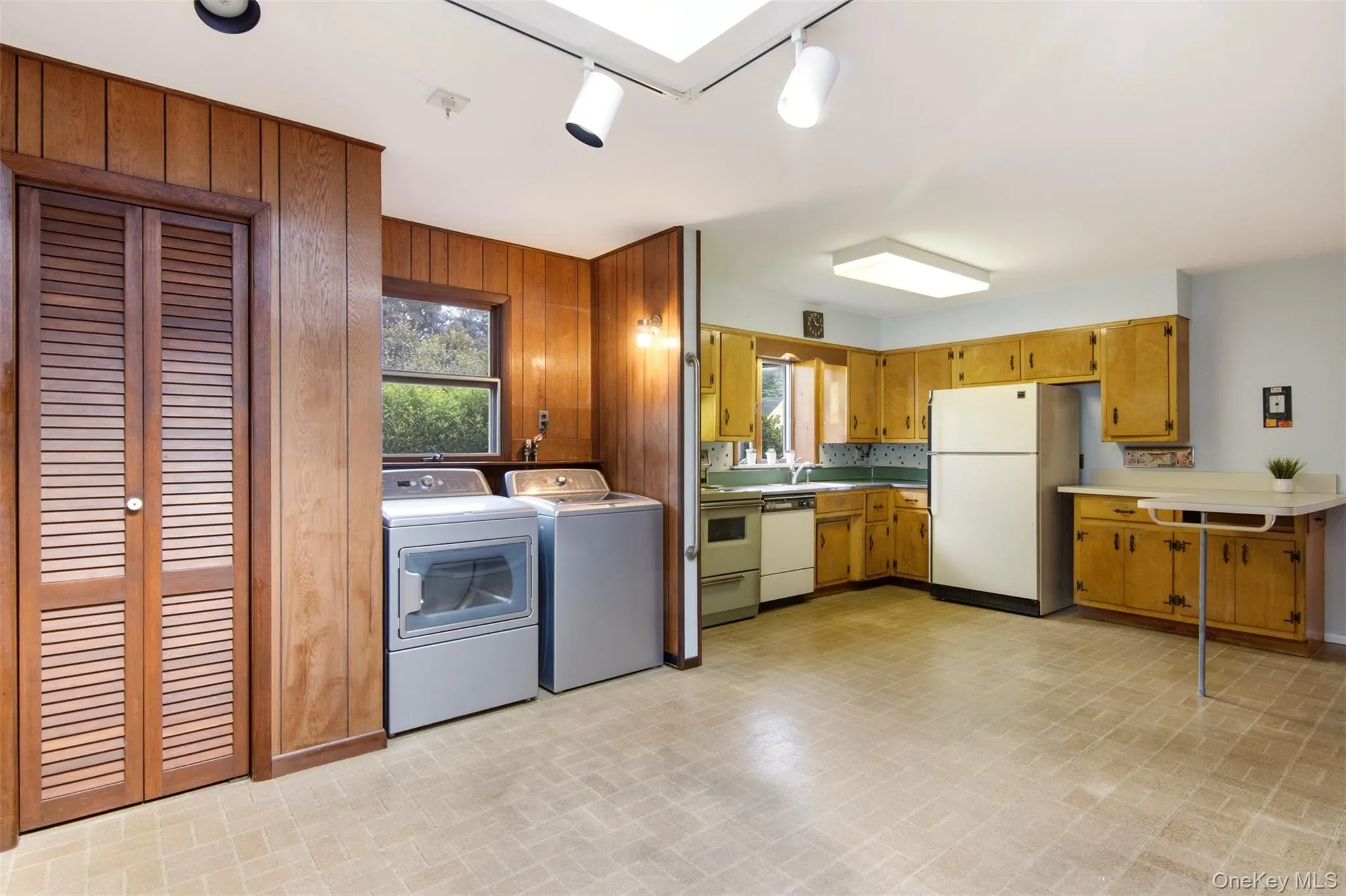 Kitchen with pantry closet, laundry, wood cabinets and breakfast bar. (Dishwasher AS-IS) Kitchen with pantry closet, laundry, wood cabinets and breakfast bar. (Dishwasher AS-IS)