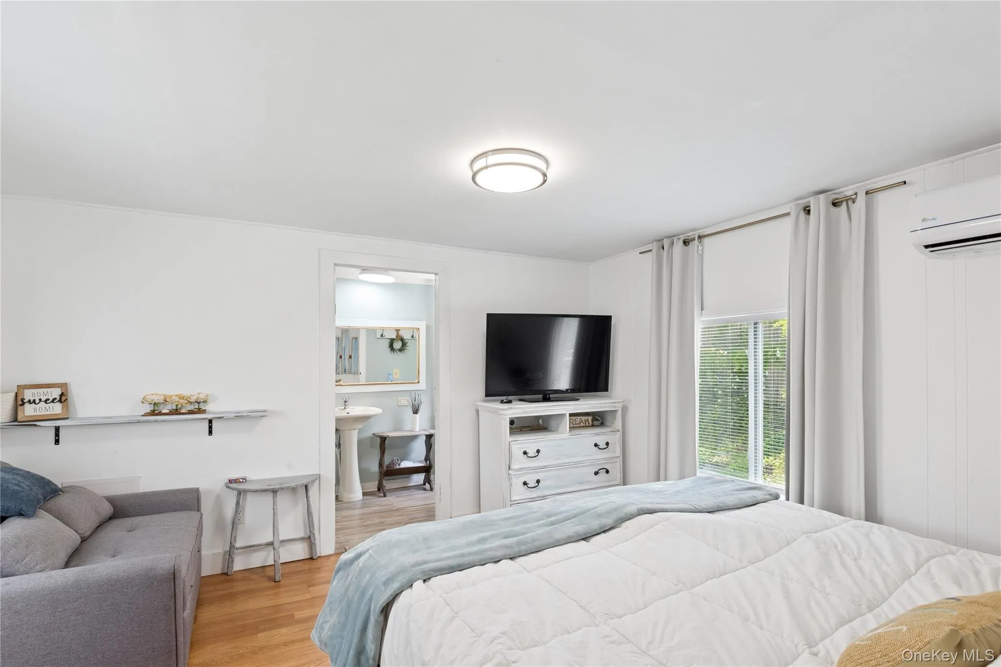 Bedroom with wood finished floors and an AC wall unit Bedroom with wood finished floors and an AC wall unit