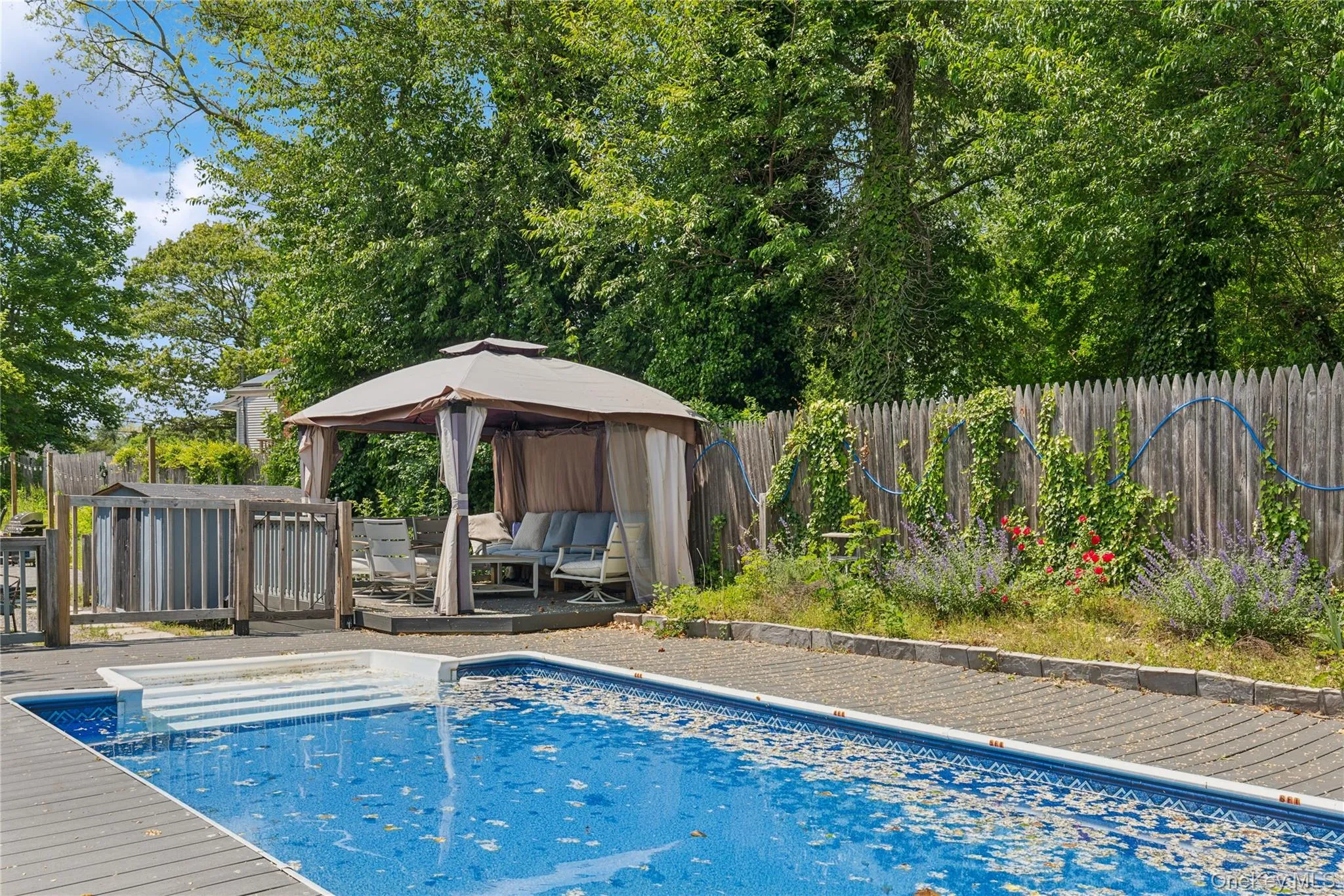 View of pool with a gazebo, a fenced backyard, an outdoor hangout area, and a deck View of pool with a gazebo, a fenced backyard, an outdoor hangout area, and a deck