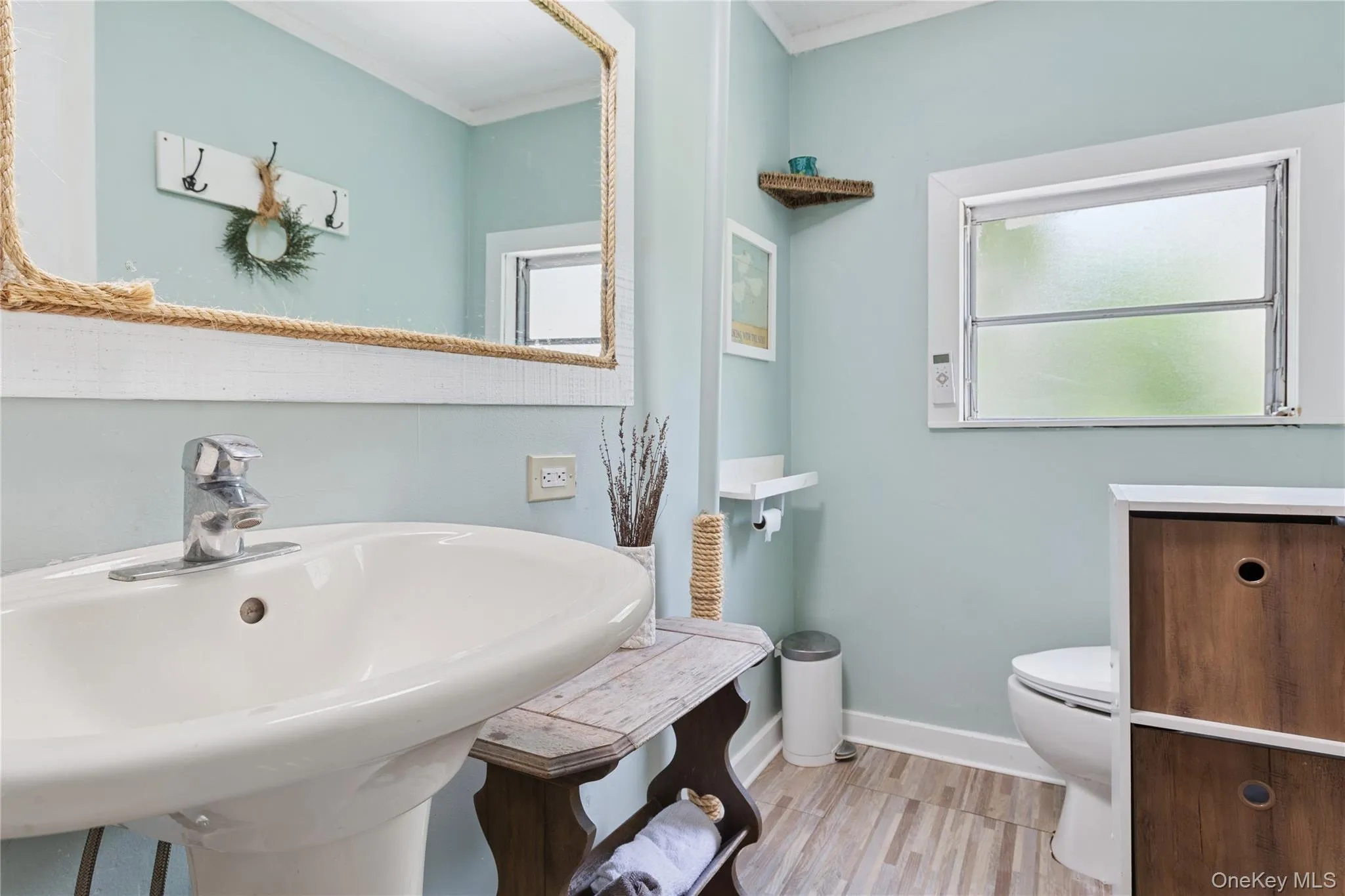 Bathroom with light wood-type flooring and ornamental molding Bathroom with light wood-type flooring and ornamental molding