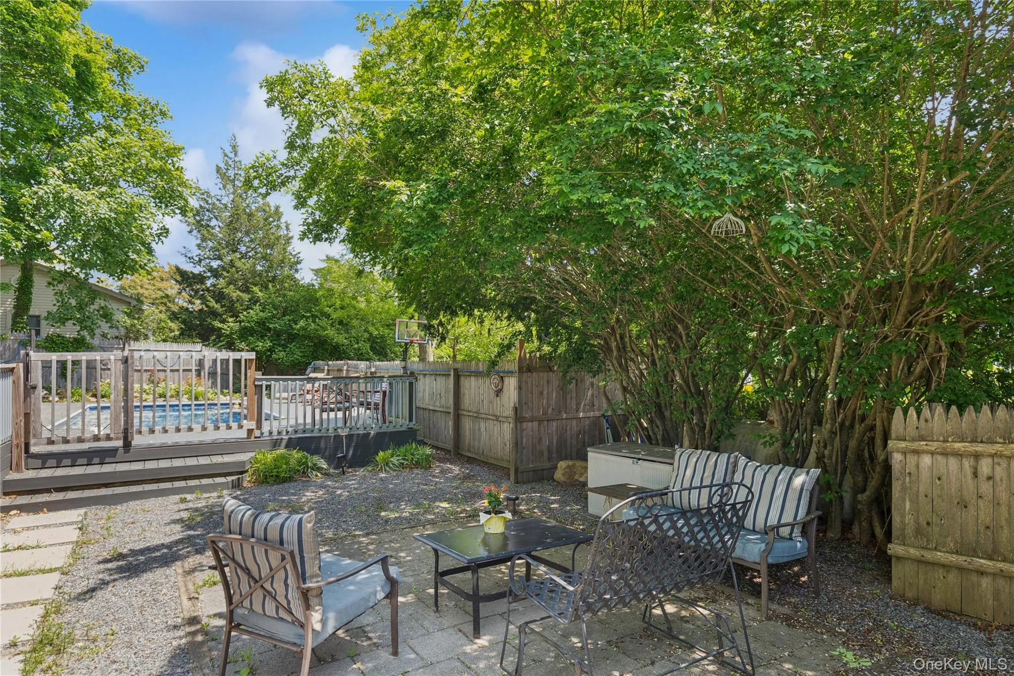 Fenced backyard with a wooden deck and a patio area Fenced backyard with a wooden deck and a patio area