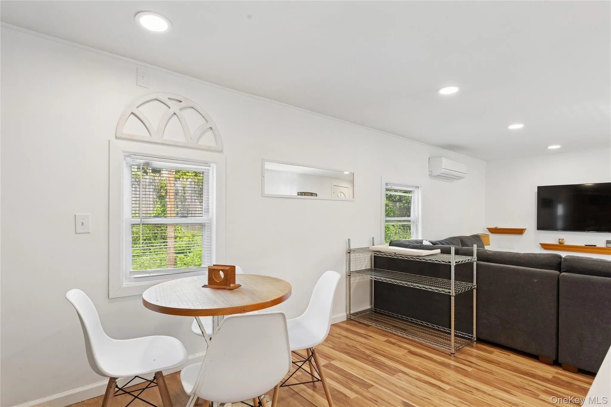 Dining room with recessed lighting, light wood finished floors, and an AC wall unit Dining room with recessed lighting, light wood finished floors, and an AC wall unit