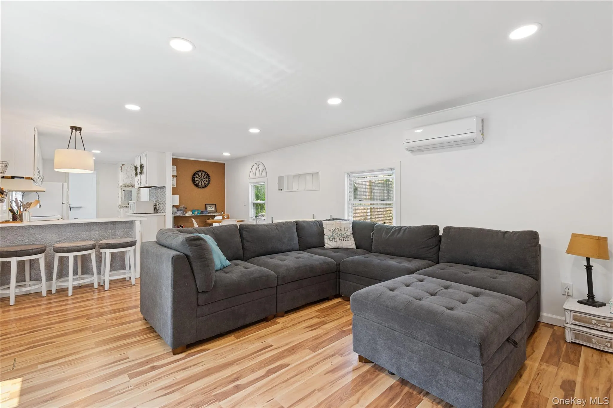 Living area featuring light wood-type flooring, recessed lighting, and a wall mounted air conditioner Living area featuring light wood-type flooring, recessed lighting, and a wall mounted air conditioner