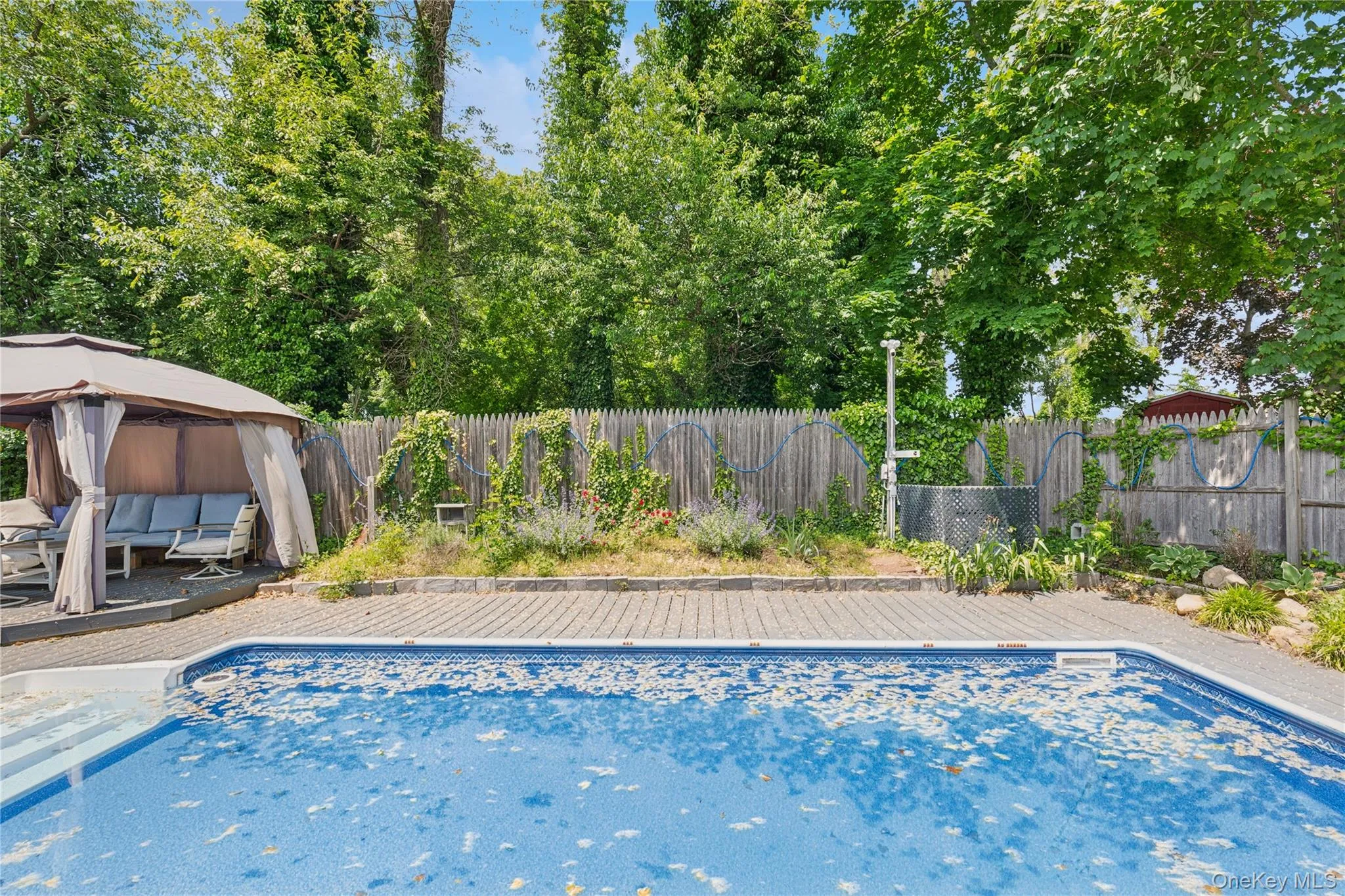 View of pool featuring a gazebo, a deck, and a fenced backyard View of pool featuring a gazebo, a deck, and a fenced backyard