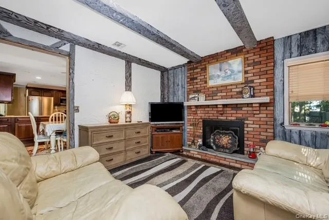 Family Room with Wood Burning Fireplace has 2 Windows for Natural Light. windonatural The Wood Floors and Beams on the Ceiling Make this Room a Cozy Retreat Family Room with Wood Burning Fireplace has 2 Windows for Natural Light. windonatural The Wood Floors and Beams on the Ceiling Make this Room a Cozy Retreat