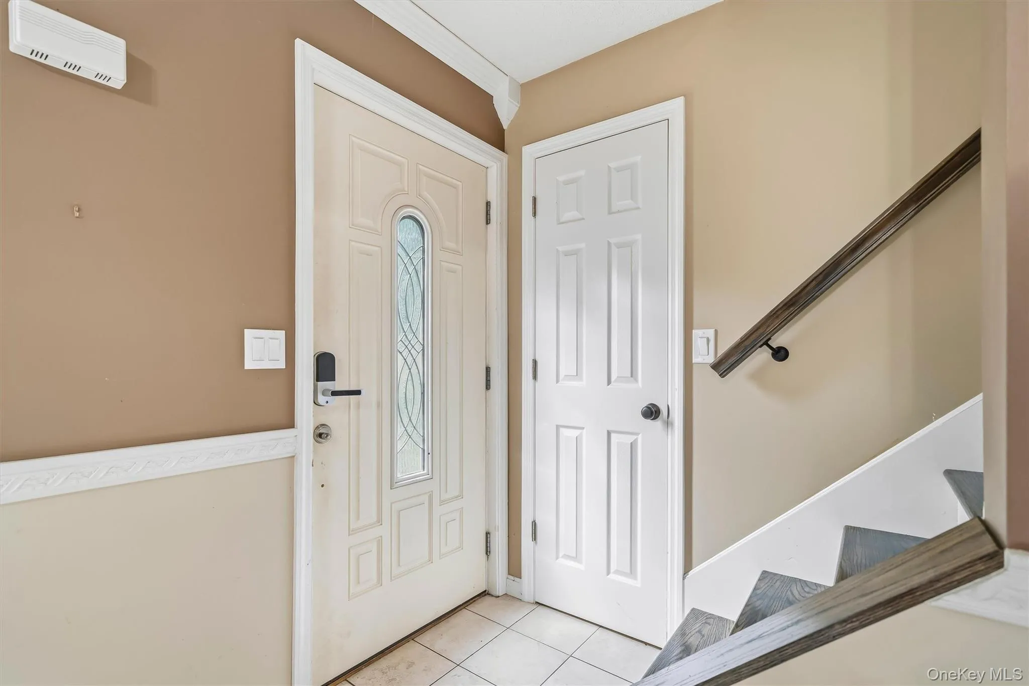 Front entry with tiled flooring and staircase leading to the upper level. Front entry with tiled flooring and staircase leading to the upper level.