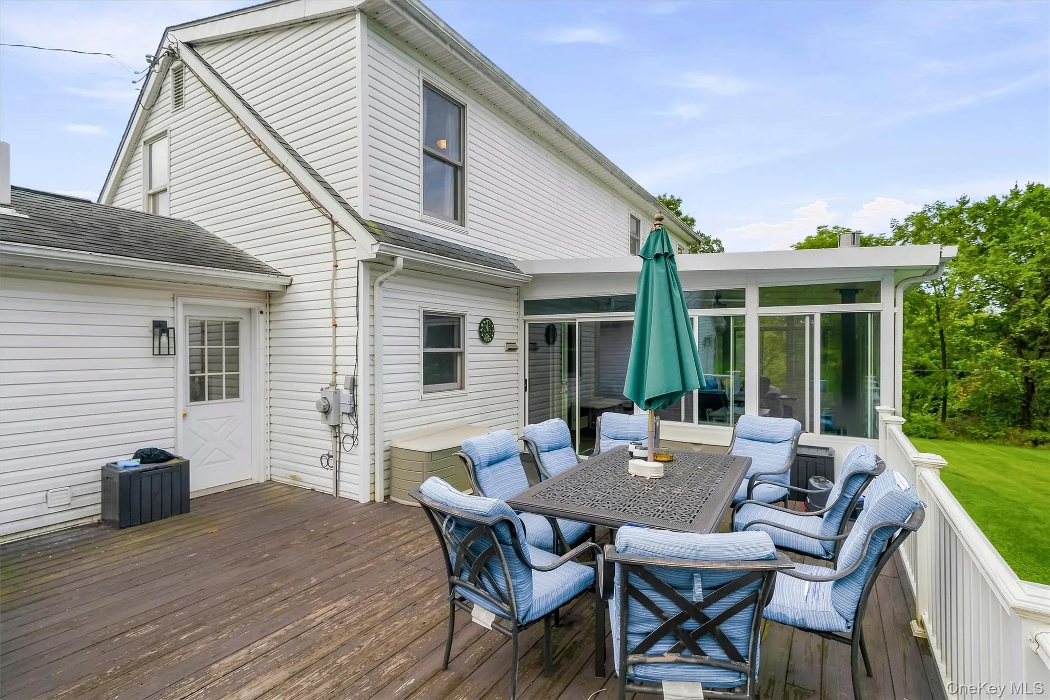 Spacious deck with outdoor dining area and direct access to the enclosed sunroom. Spacious deck with outdoor dining area and direct access to the enclosed sunroom.
