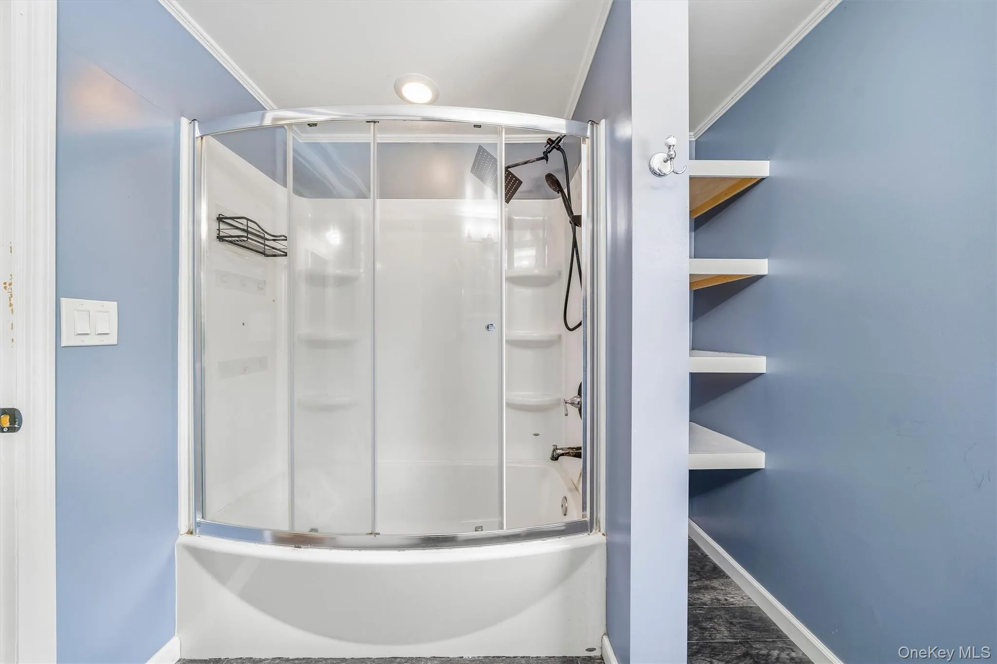 Shower tub combination with clear glass enclosure and built-in shelving Shower tub combination with clear glass enclosure and built-in shelving