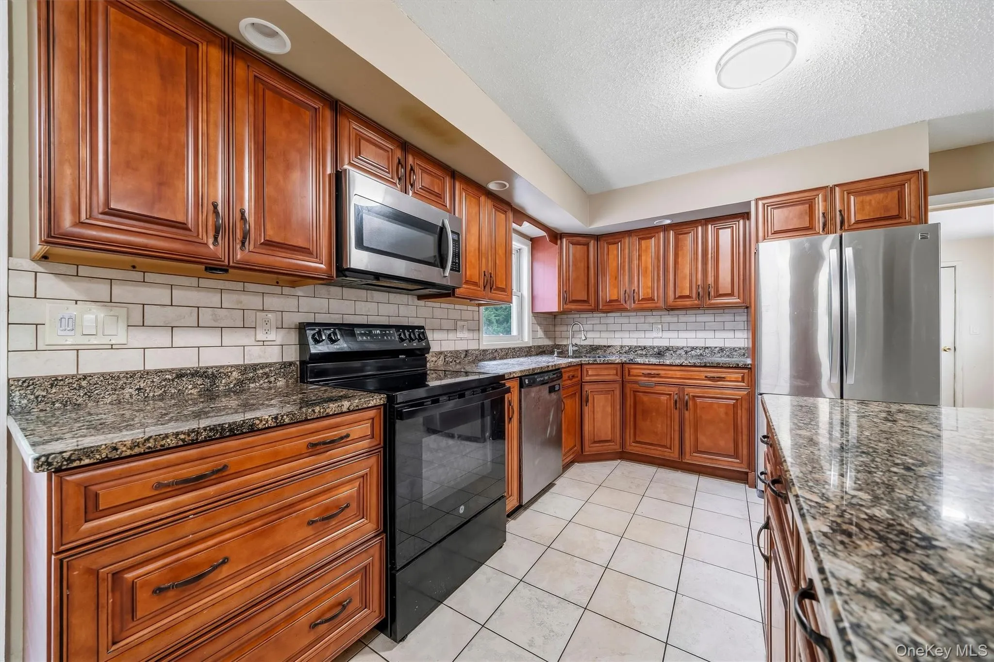 Ample counter space and cabinetry with granite countertops and tiled backsplash. Ample counter space and cabinetry with granite countertops and tiled backsplash.