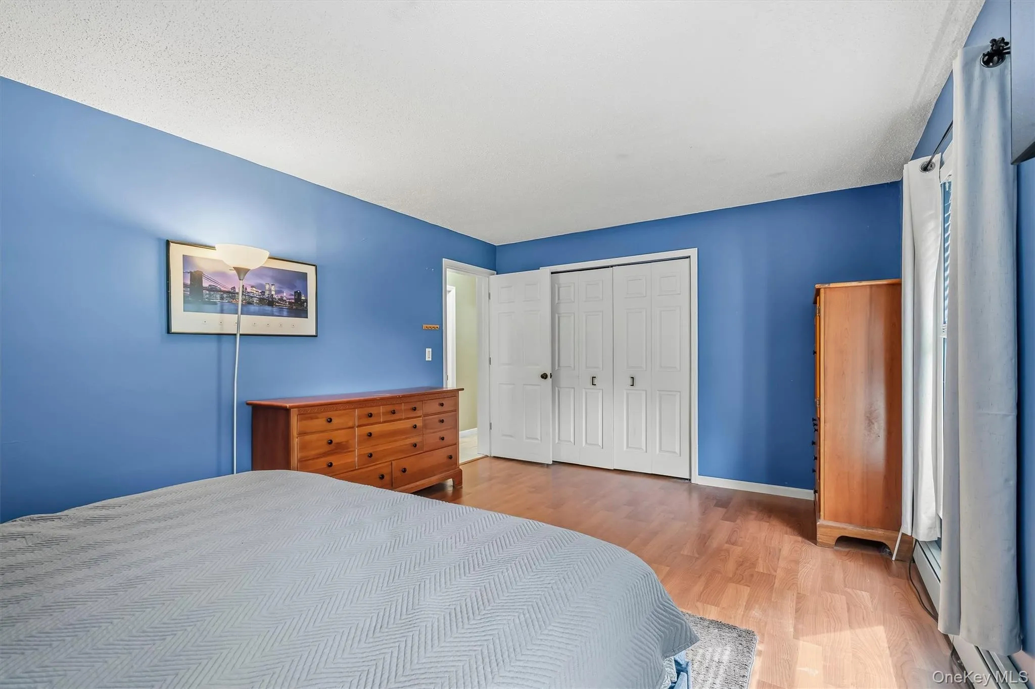 Spacious primary bedroom with hardwood flooring and ample closet space. Spacious primary bedroom with hardwood flooring and ample closet space.