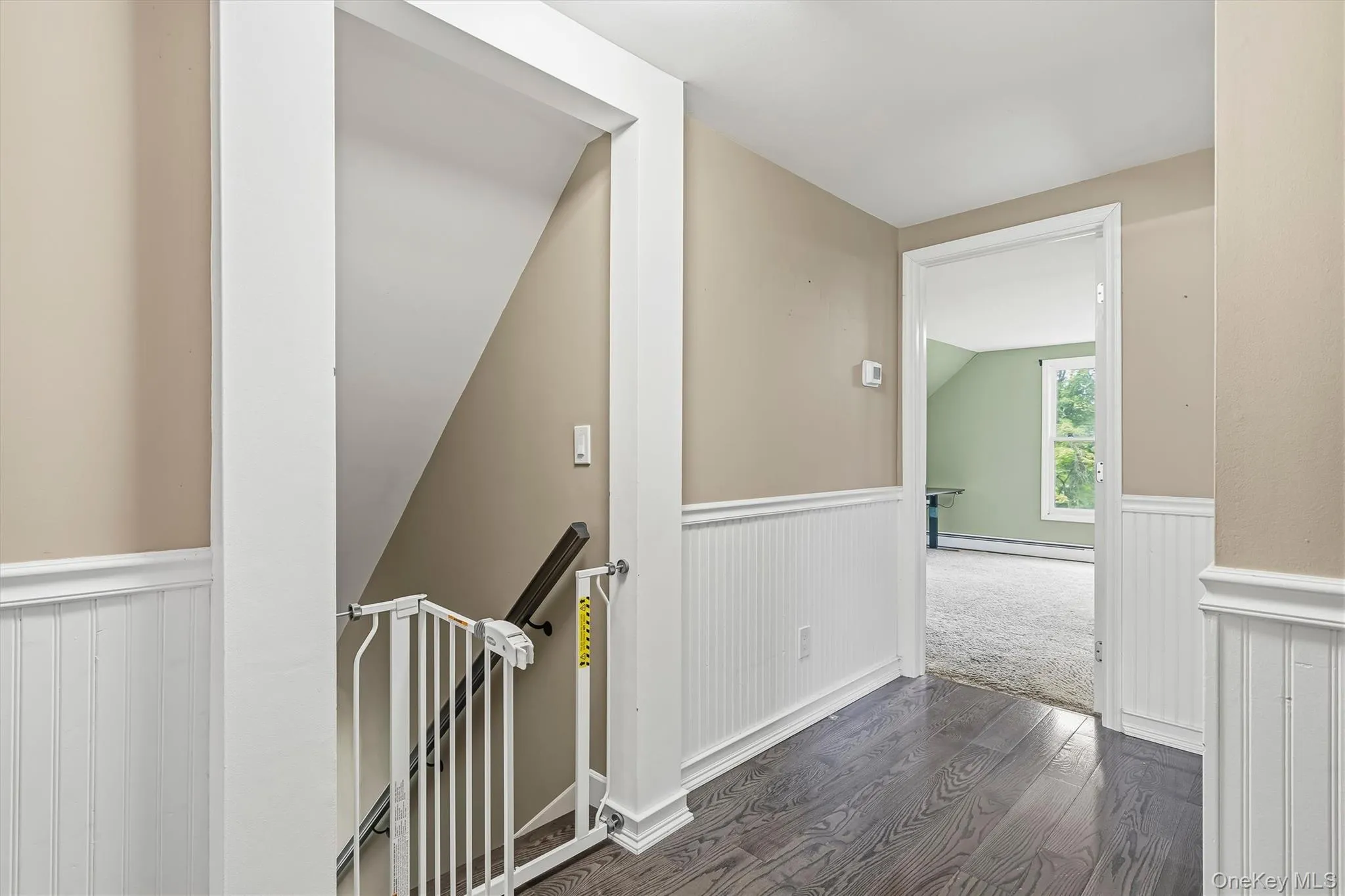 Wood-finish flooring, half-wall wainscoting, and neutral wall tones Wood-finish flooring, half-wall wainscoting, and neutral wall tones