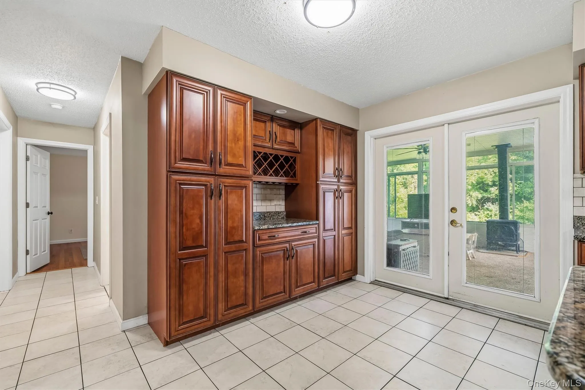 Additional kitchen view highlighting extensive cabinetry and access to the sunroom. Additional kitchen view highlighting extensive cabinetry and access to the sunroom.
