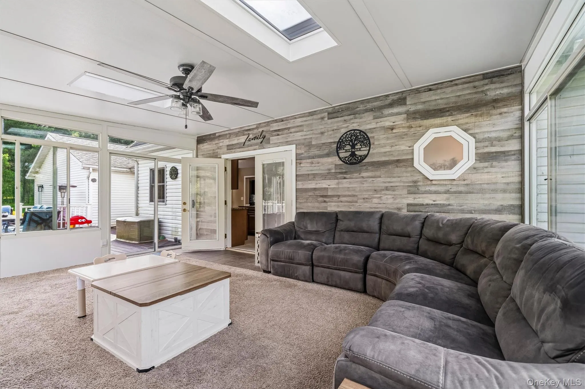 Sunroom with skylight, ceiling fan, and shiplap accent wall Sunroom with skylight, ceiling fan, and shiplap accent wall