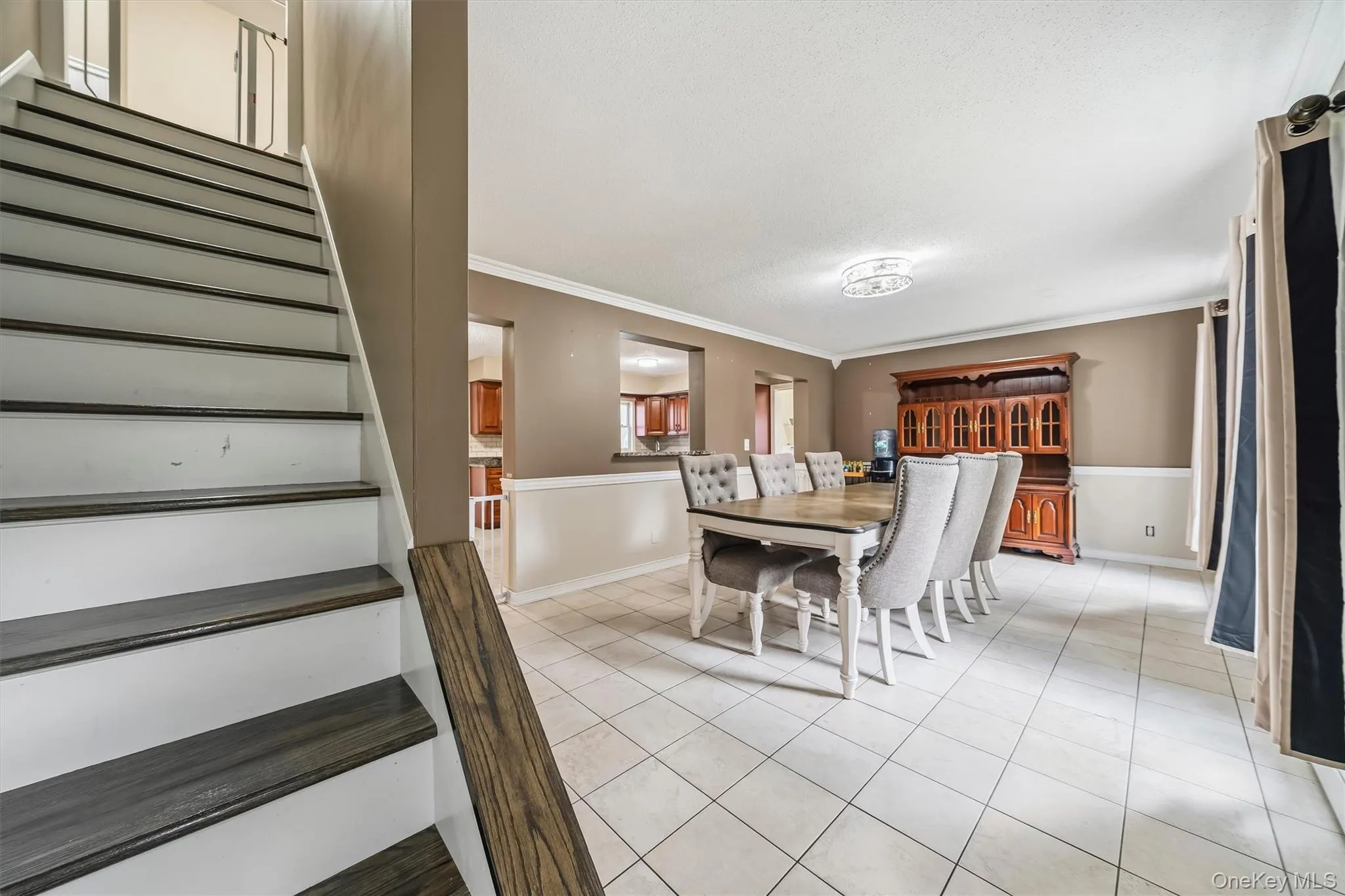 Spacious dining room with tiled flooring and an open connection to the kitchen. Spacious dining room with tiled flooring and an open connection to the kitchen.