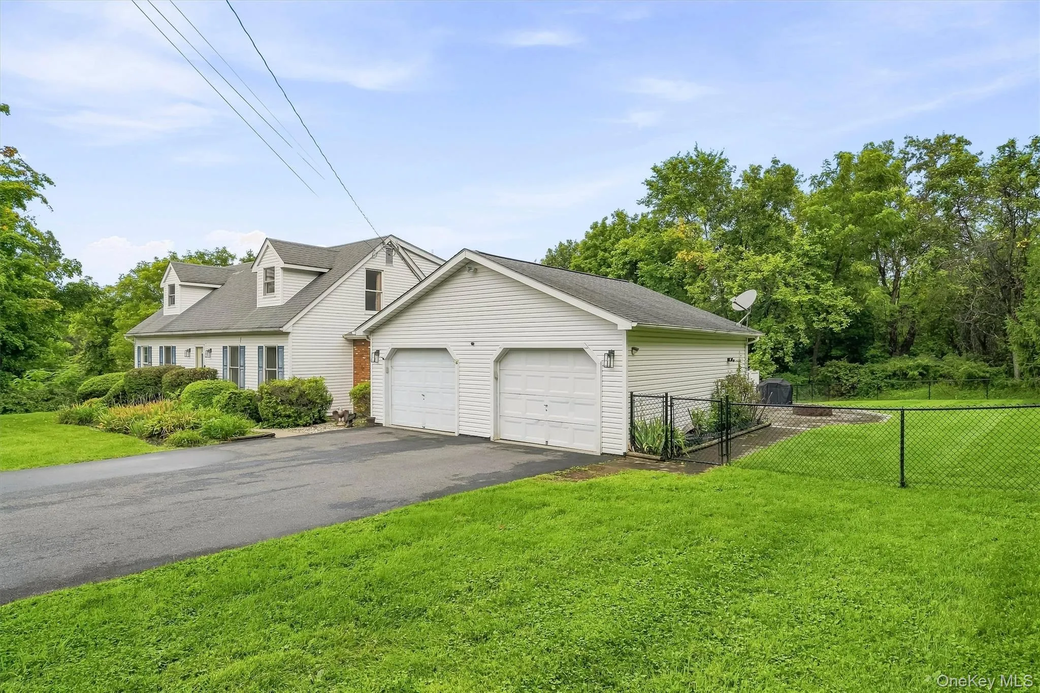 Attached two-car garage with paved driveway and fenced yard area. Attached two-car garage with paved driveway and fenced yard area.