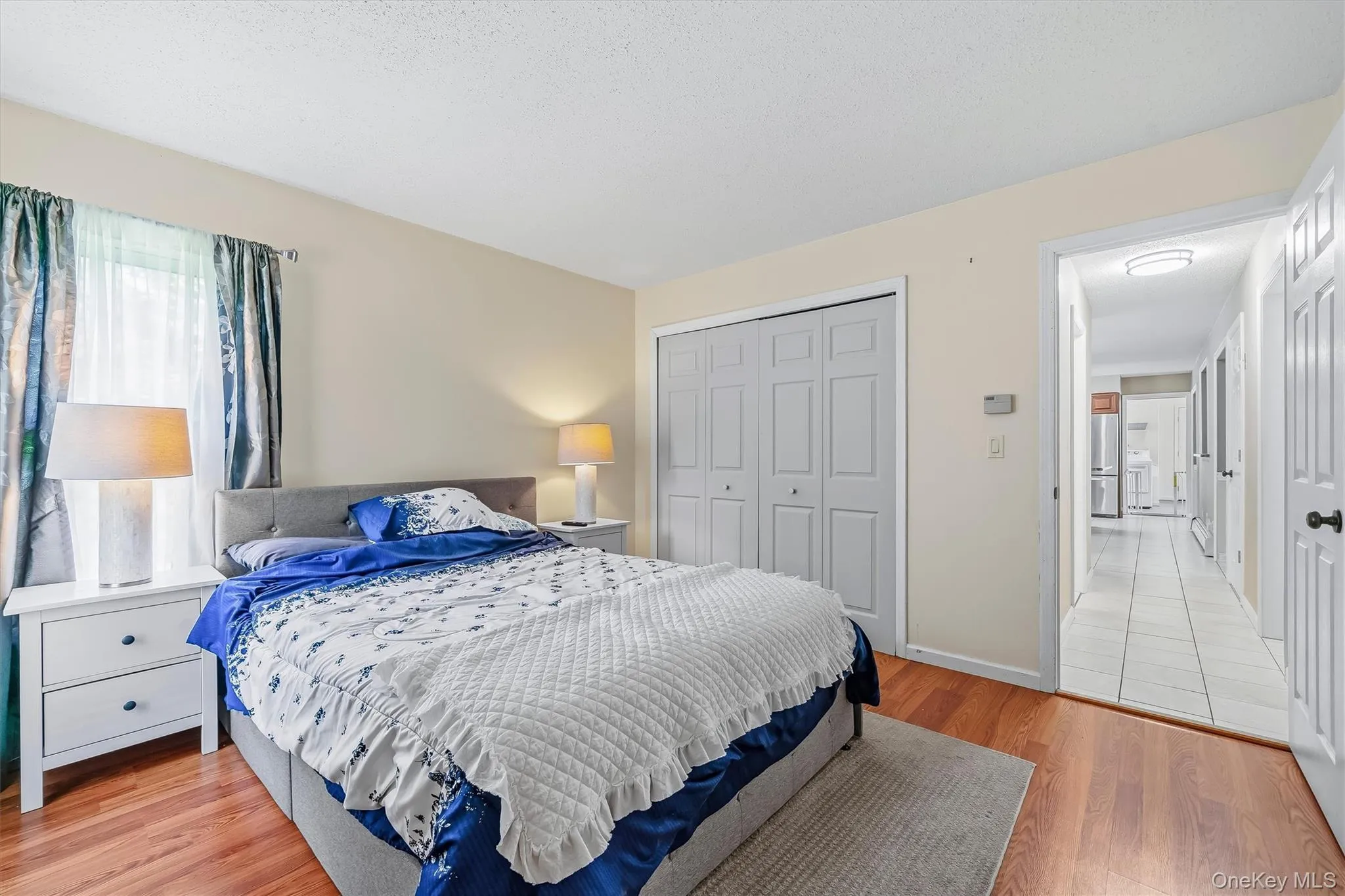 Wood-finish flooring, bi-fold closet doors, and recessed lighting in the hallway Wood-finish flooring, bi-fold closet doors, and recessed lighting in the hallway