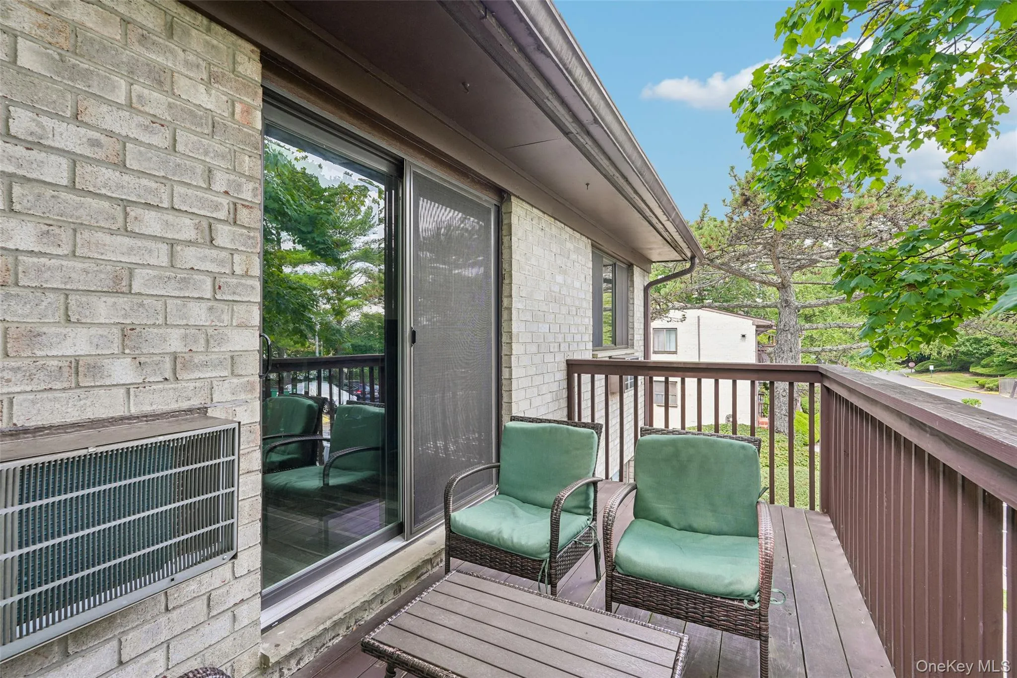 Private outdoor balcony with wood-finish decking and dark wood railings Private outdoor balcony with wood-finish decking and dark wood railings