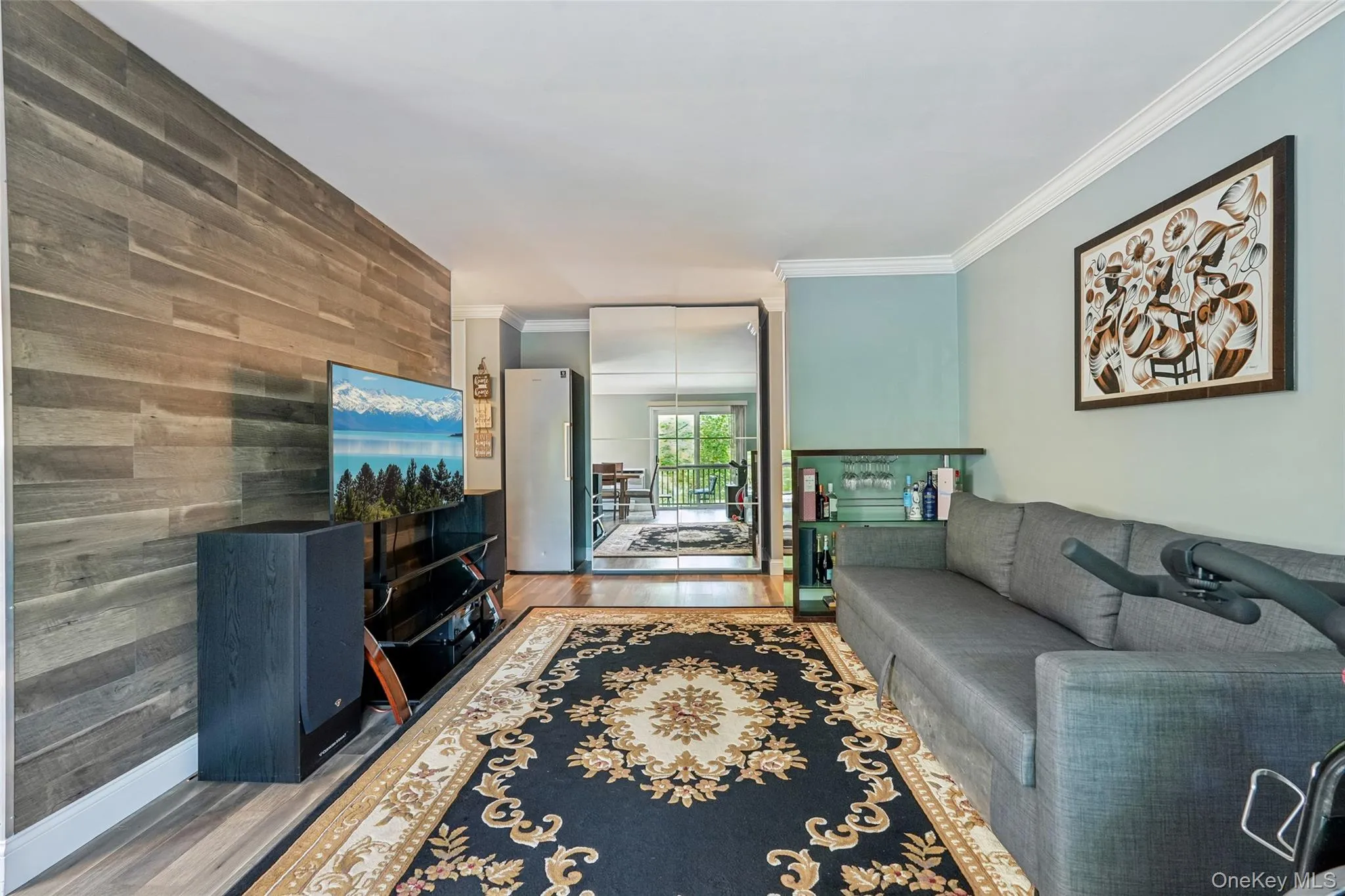 Wood-finish accent wall, crown molding, wood-finish flooring, mirrored sliding doors, built-in shelving unit Wood-finish accent wall, crown molding, wood-finish flooring, mirrored sliding doors, built-in shelving unit
