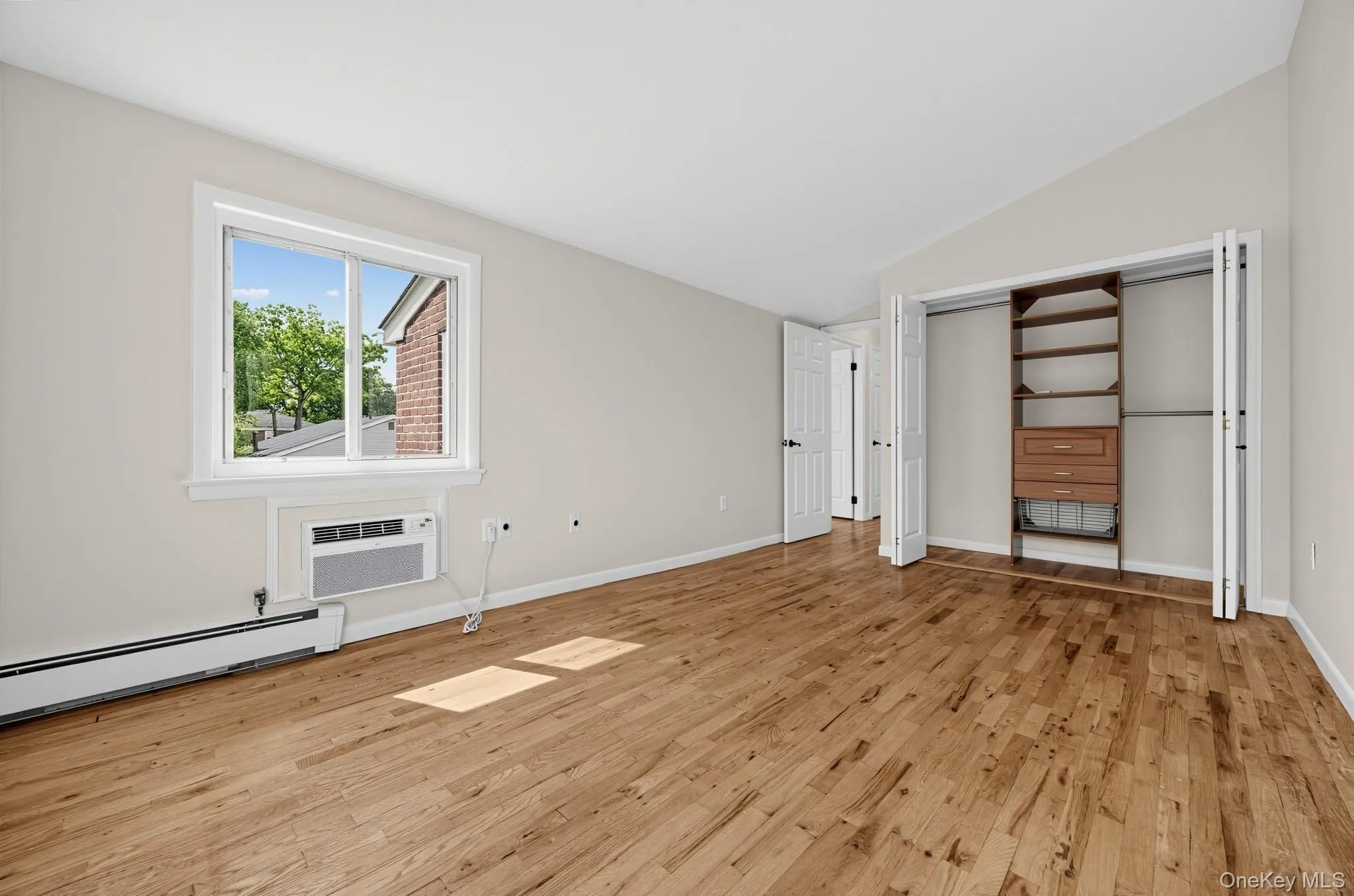 Open closet doors reveal substantial storage plus a built-in shelving and drawer system. Open closet doors reveal substantial storage plus a built-in shelving and drawer system.