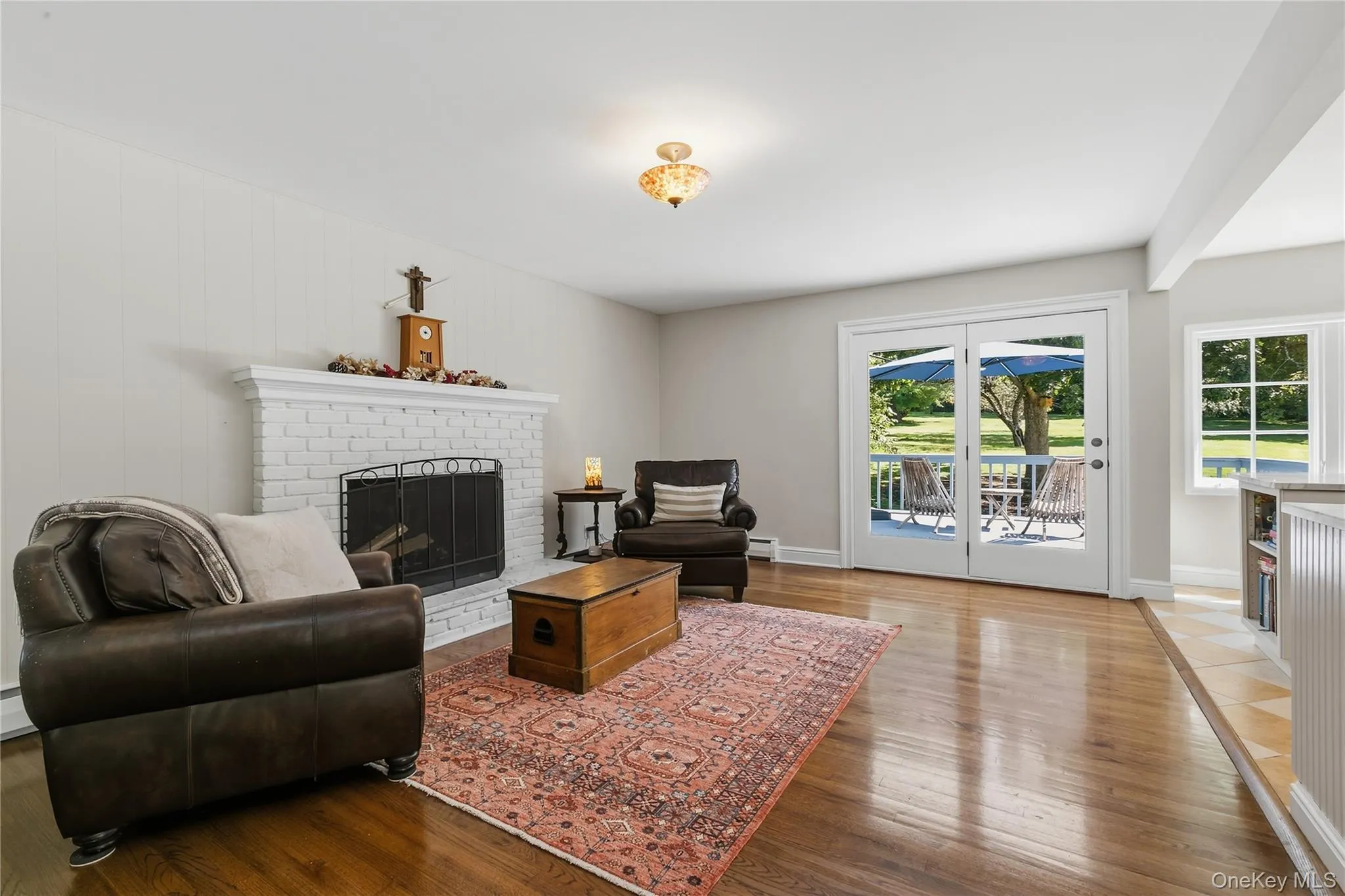 Family room with wood burning fireplace. Sliders in the background go out to spacious deck. Family room with wood burning fireplace. Sliders in the background go out to spacious deck.