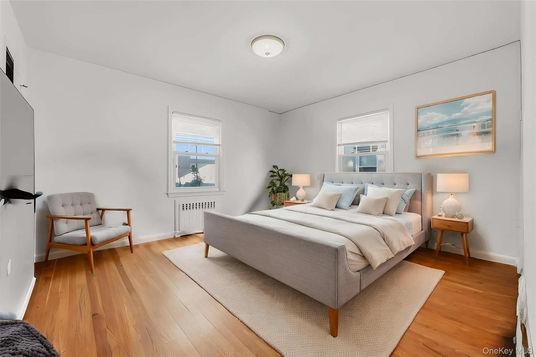Hardwood flooring throughout, two windows with window treatments, and a ceiling-mounted light fixture Hardwood flooring throughout, two windows with window treatments, and a ceiling-mounted light fixture
