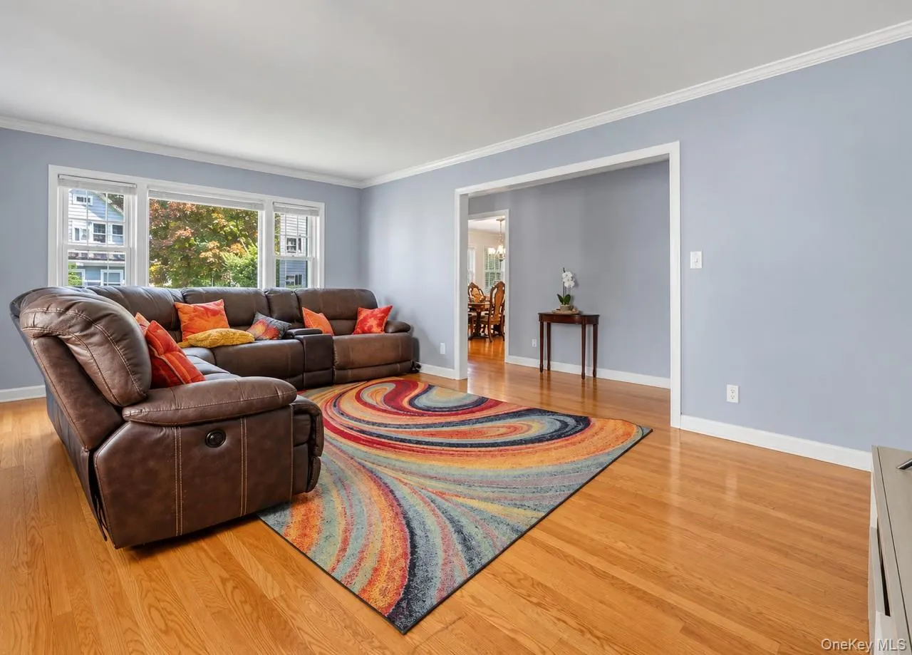 Hardwood flooring, crown molding, wide baseboards, light blue wall paint, and white trim Hardwood flooring, crown molding, wide baseboards, light blue wall paint, and white trim