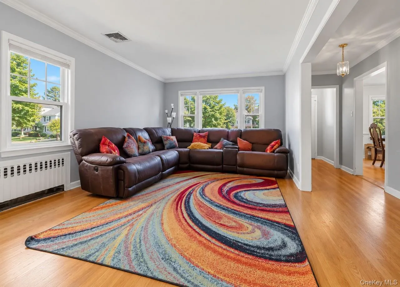 Hardwood flooring throughout, crown molding, double-hung windows, arched entryway, and a hanging light fixture Hardwood flooring throughout, crown molding, double-hung windows, arched entryway, and a hanging light fixture