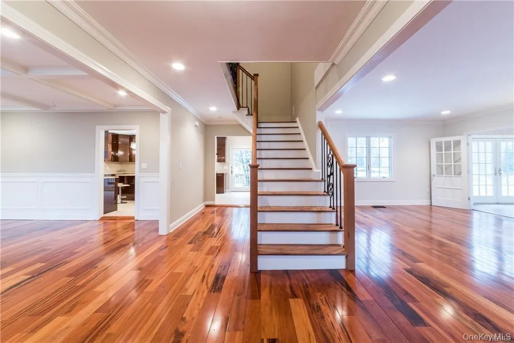 Stairs with hardwood / wood-style floors, plenty of natural light, ornamental molding, recessed lighting, and wainscoting Stairs with hardwood / wood-style floors, plenty of natural light, ornamental molding, recessed lighting, and wainscoting