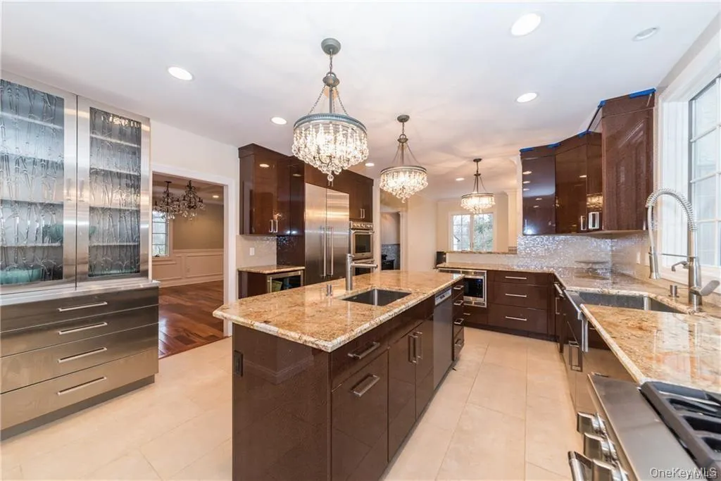 Kitchen with a chandelier, built in appliances, a sink, light tile patterned floors, and recessed lighting Kitchen with a chandelier, built in appliances, a sink, light tile patterned floors, and recessed lighting