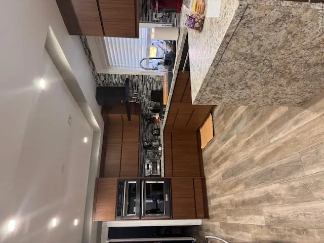 Kitchen lower level featuring sink, decorative backsplash, and exhaust hood Kitchen lower level featuring sink, decorative backsplash, and exhaust hood