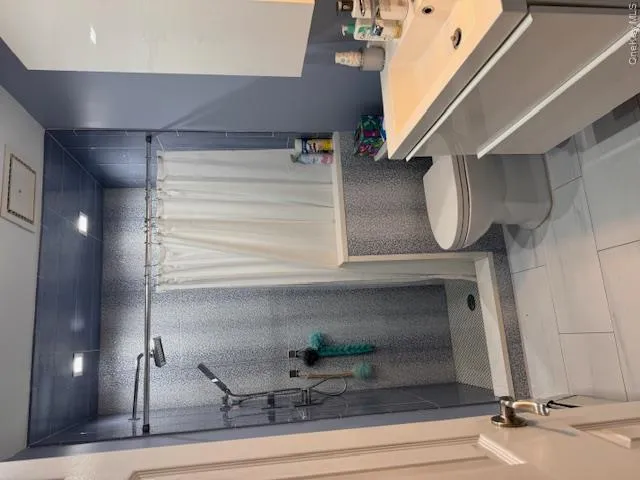 Bathroom featuring vanity, toilet, a shower with curtain, and tile patterned flooring Bathroom featuring vanity, toilet, a shower with curtain, and tile patterned flooring