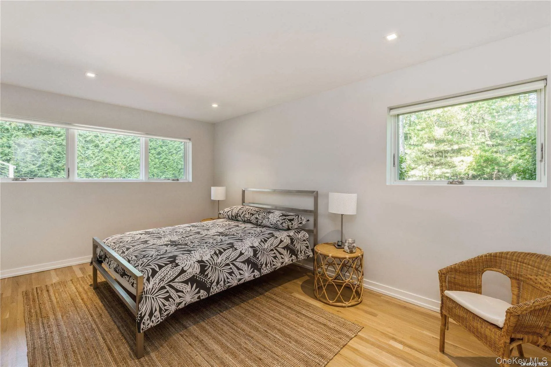 Bedroom featuring multiple windows, light wood-style flooring, and recessed lighting Bedroom featuring multiple windows, light wood-style flooring, and recessed lighting