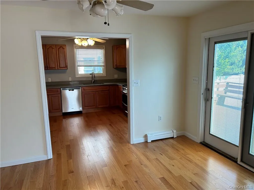 Kitchen with stainless steel appliances, ceiling fan, and light wood-type flooring Kitchen with stainless steel appliances, ceiling fan, and light wood-type flooring