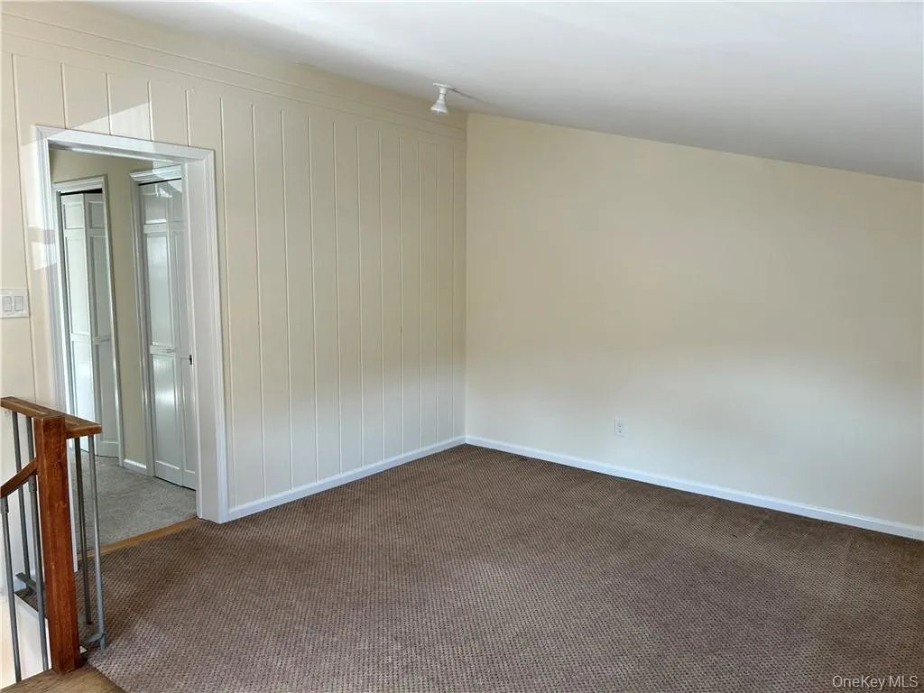 Unfurnished room with dark colored carpet Unfurnished room with dark colored carpet